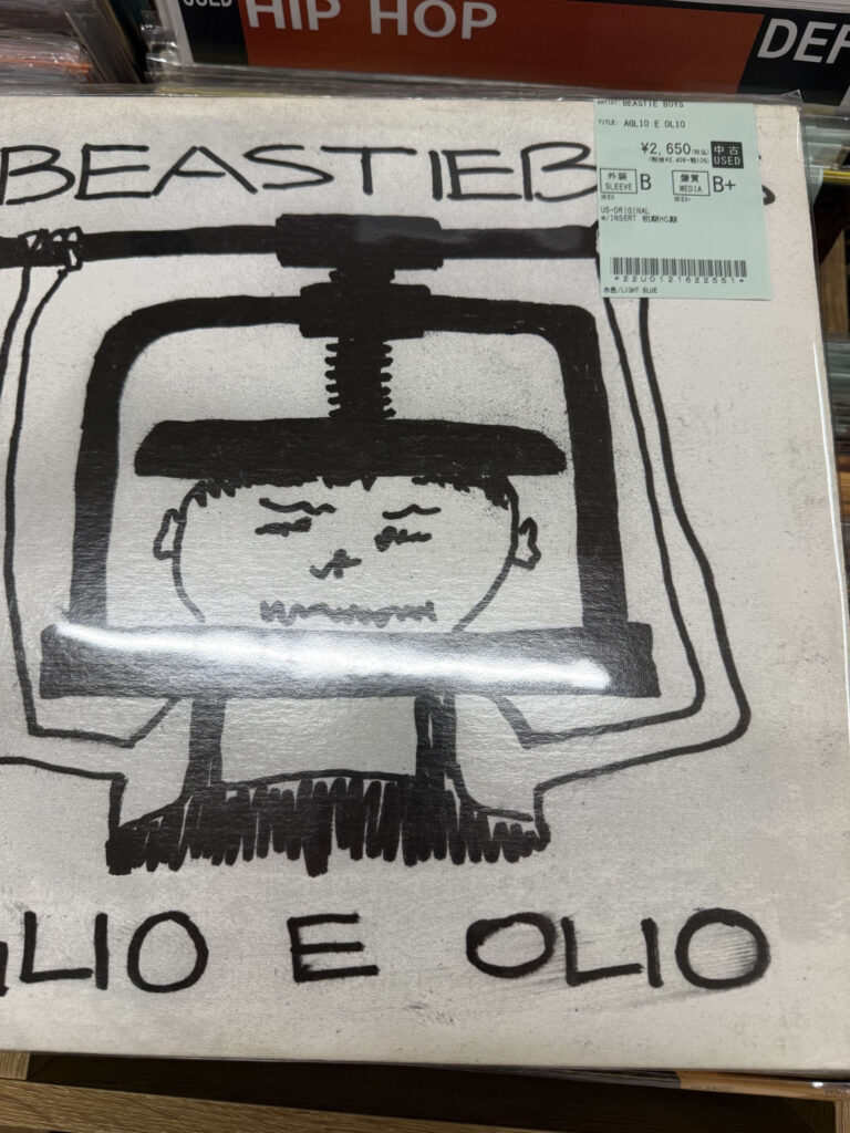 ビースティ・ボーイズのEP『Aglio E Olio』のアナログレコードジャケット。万力で頭を締め付けられている人物の線画イラスト。