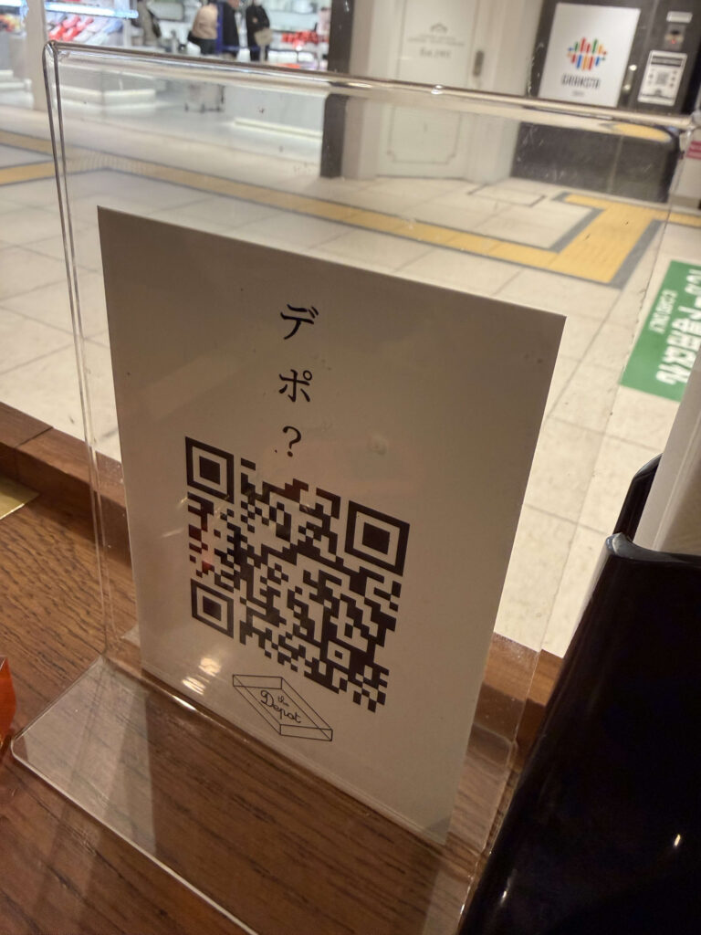 Acrylic table stand featuring a QR code and 'Depo?' text on a wooden surface