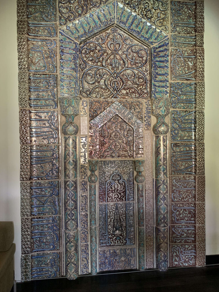 Intricate lustreware mihrab tilework featuring complex Arabic calligraphy and floral patterns