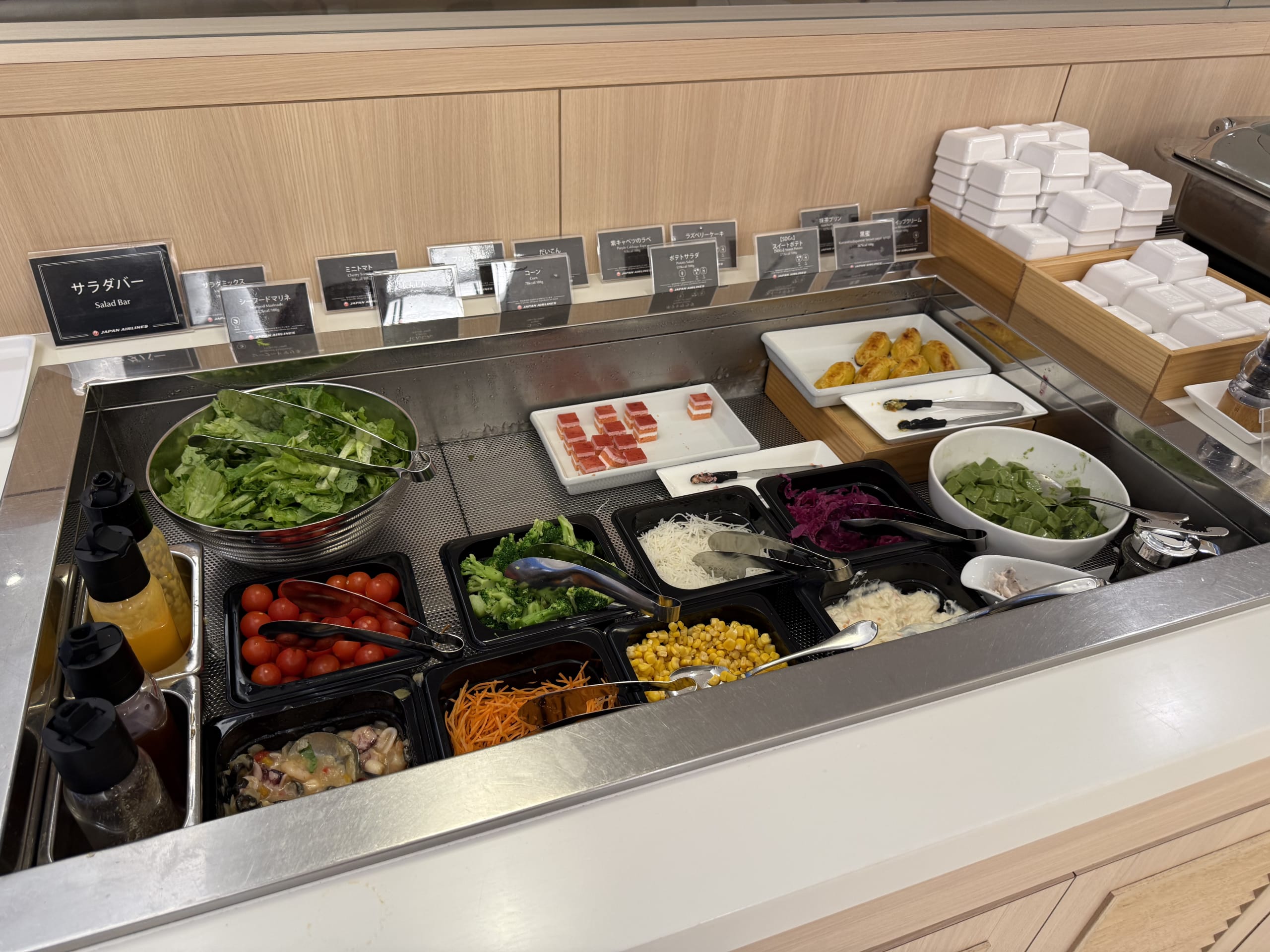 Lounge salad bar with fresh veggies and desserts.