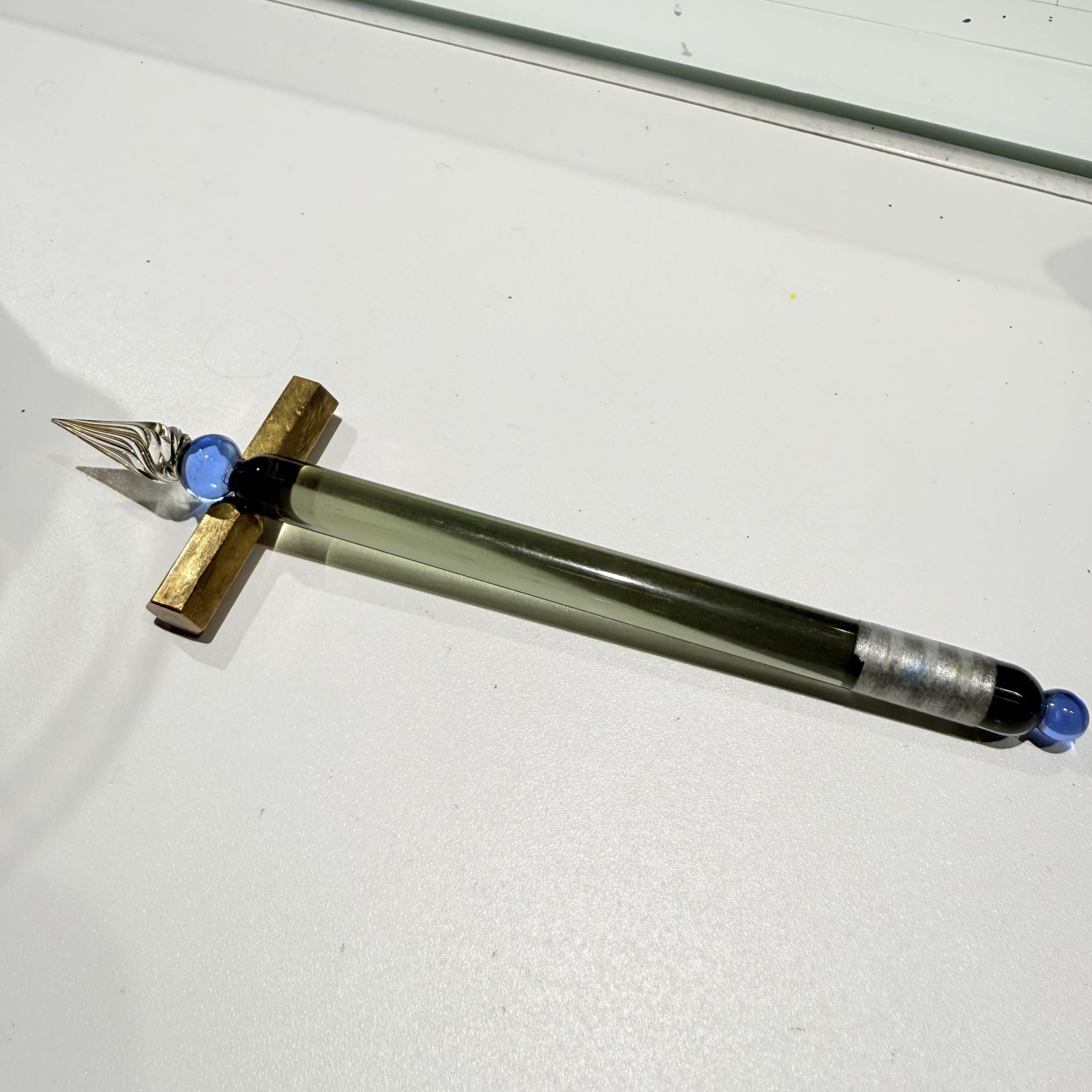 真鍮のペンレストに置かれたガラスペン。