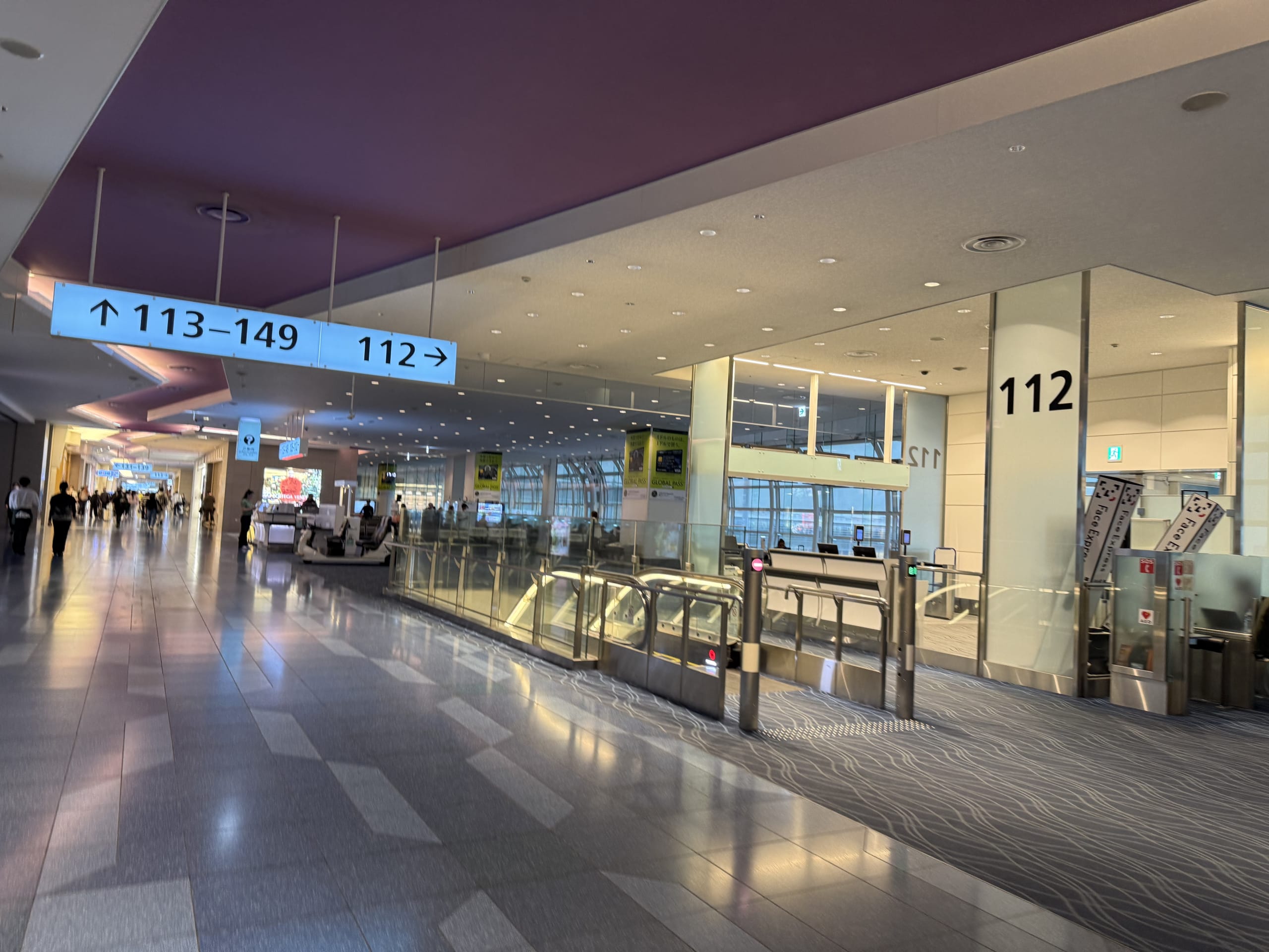 Airport departure area with a sign for gate 112.
