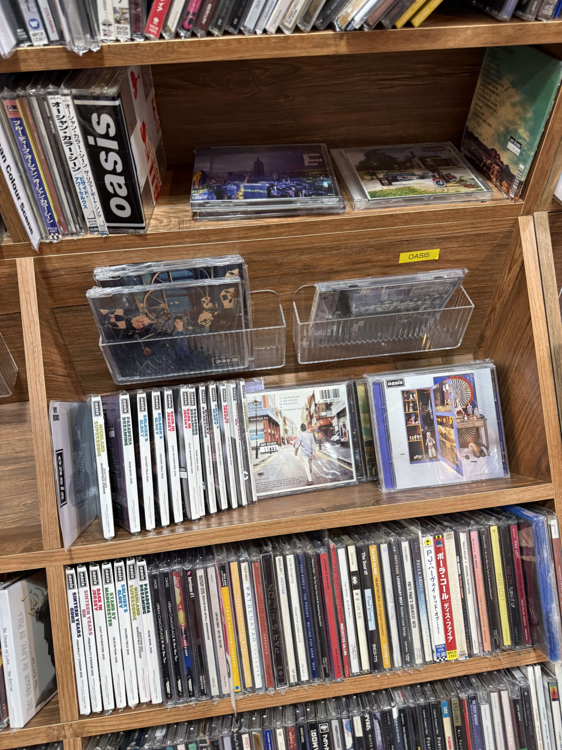 レコード店の棚に陳列された多数のOasisのCD