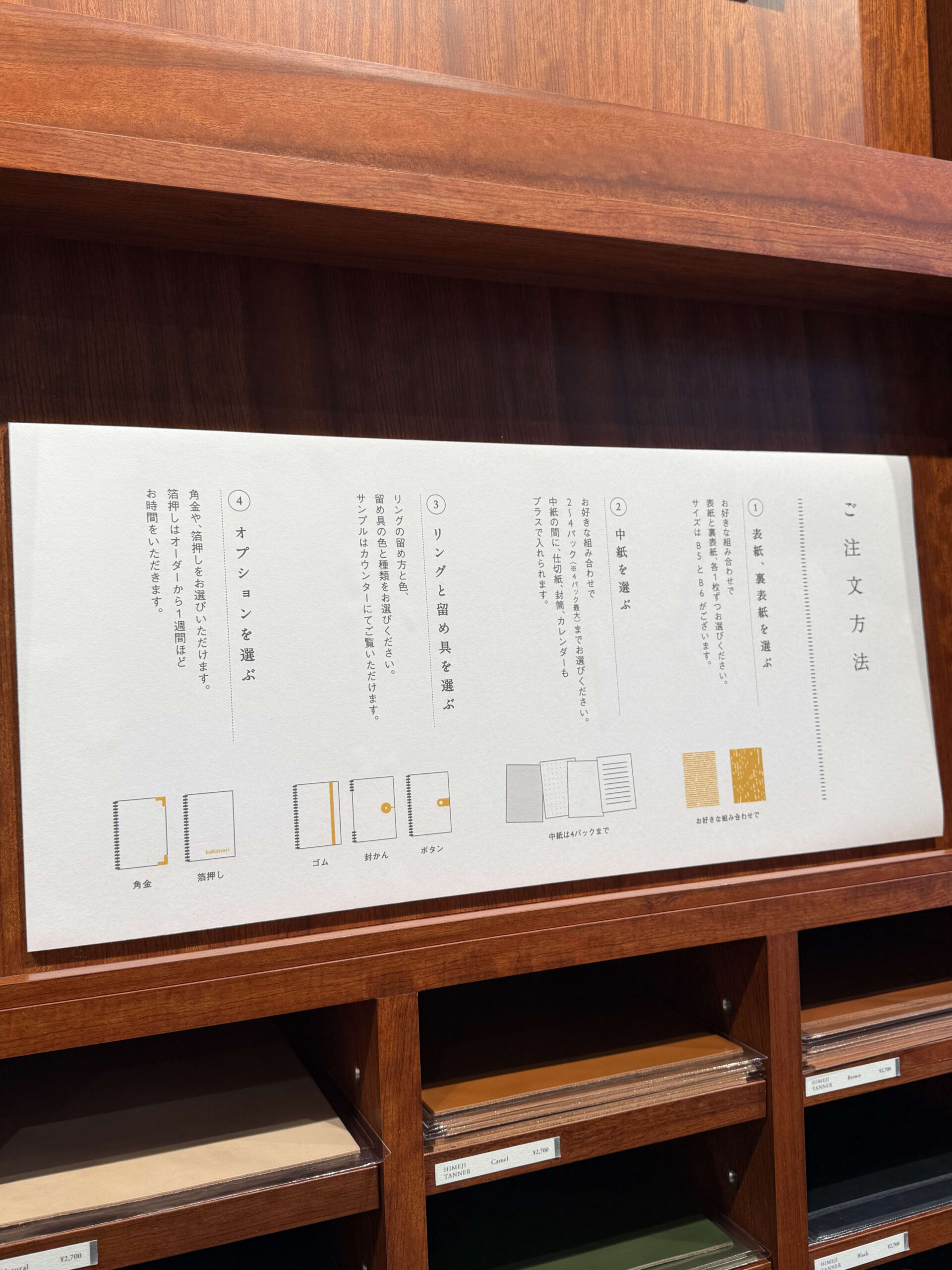Kakimori's notebook order guide on a wooden shelf.