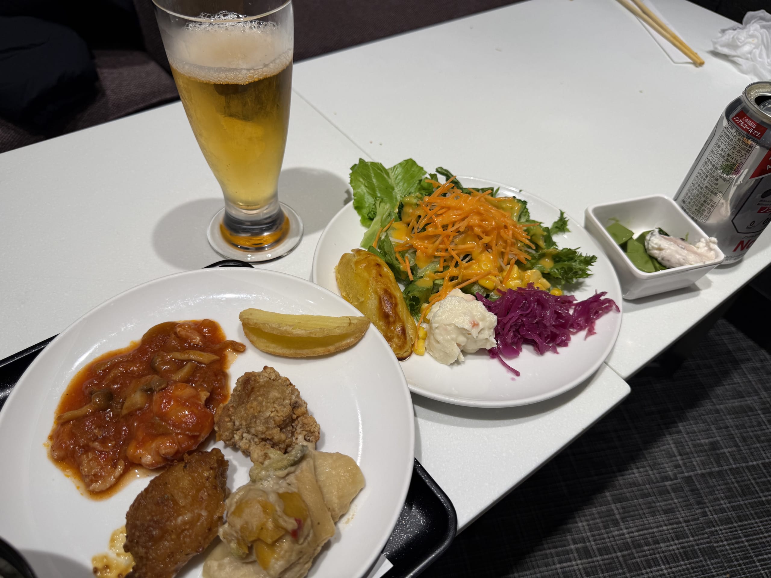 Buffet plates with beer, salad and fried chicken.