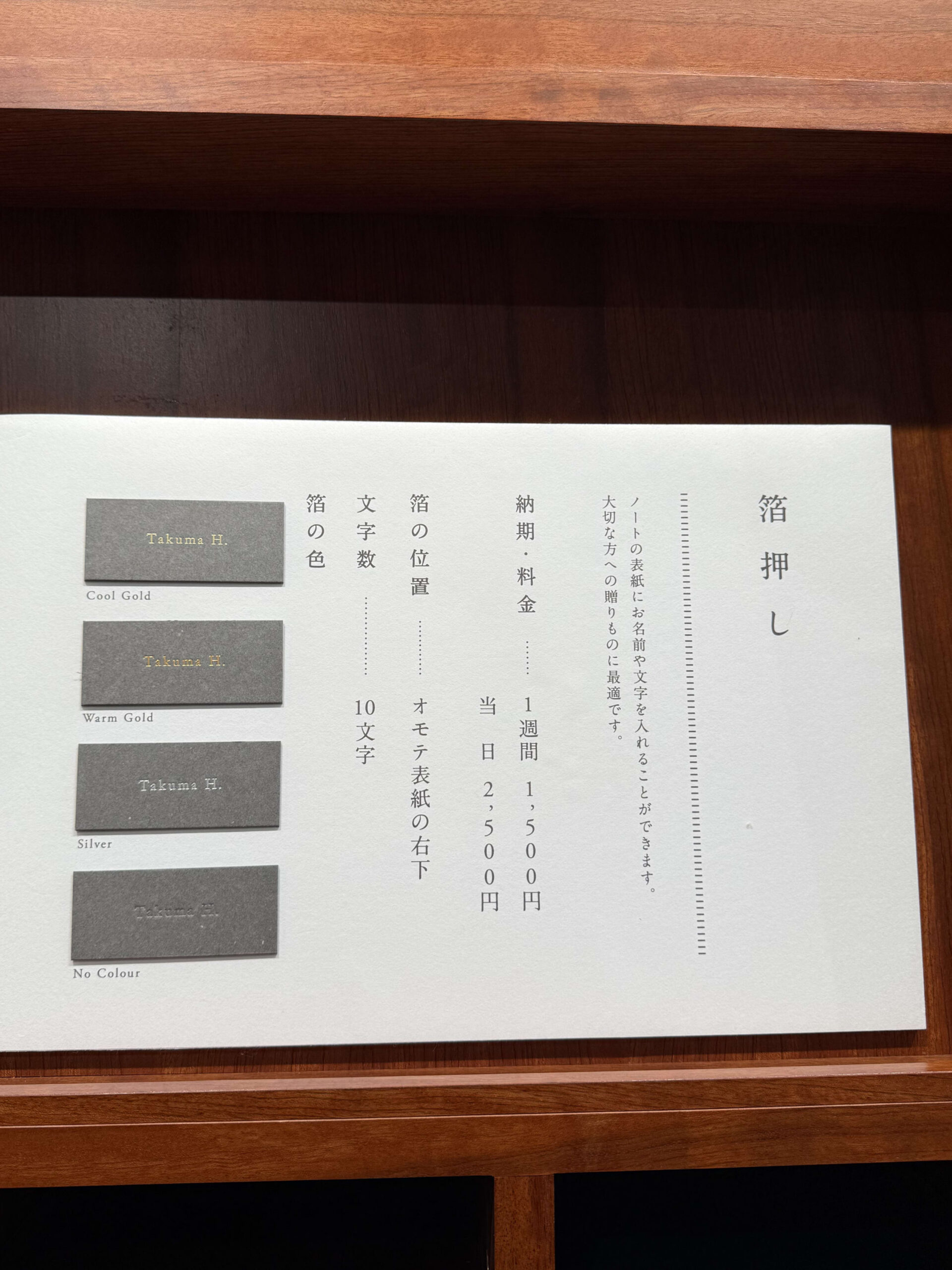 Foil stamping menu and samples on a wood counter.