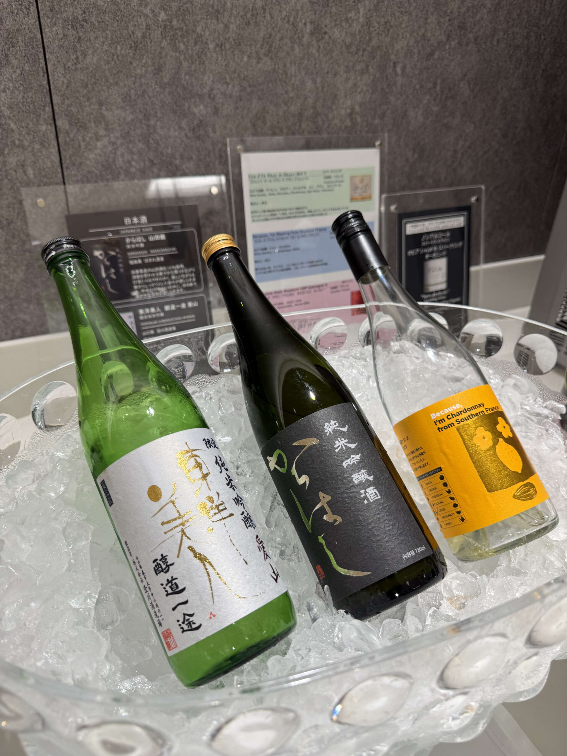 Bottles of sake and wine chilling on ice.