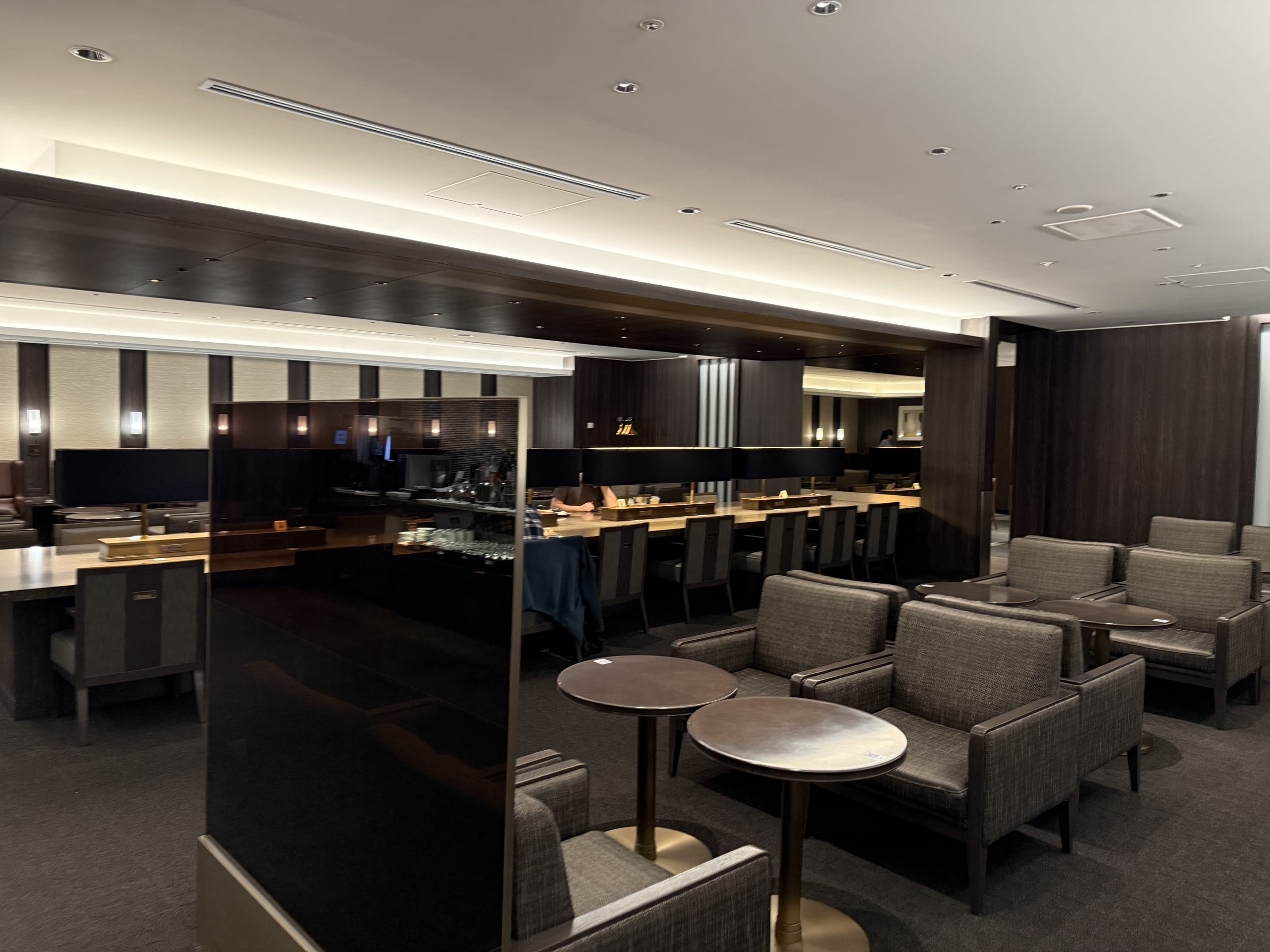 Quiet lounge with dark wood decor and long desk.