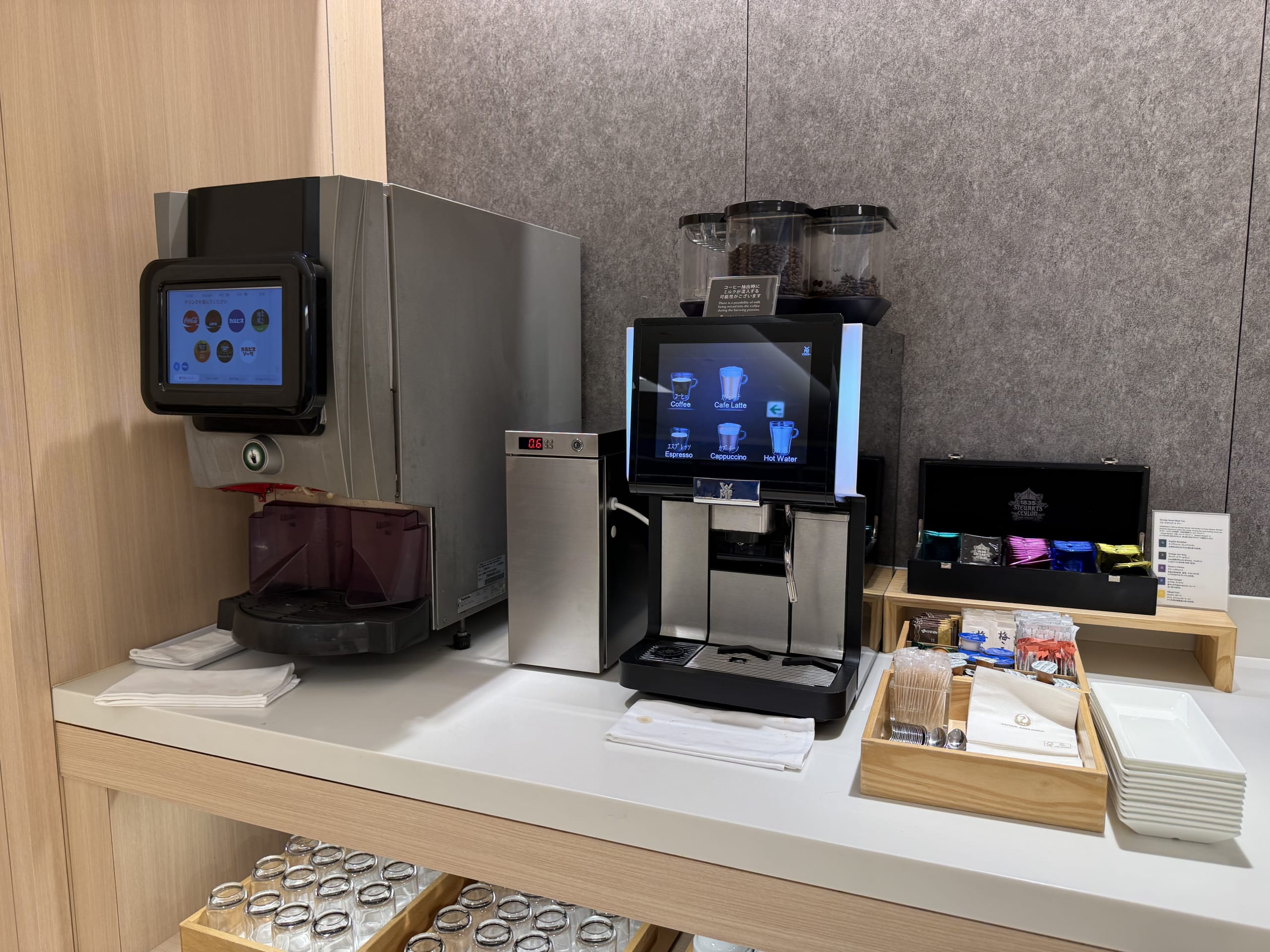Coffee machine and drink dispenser on a lounge counter.