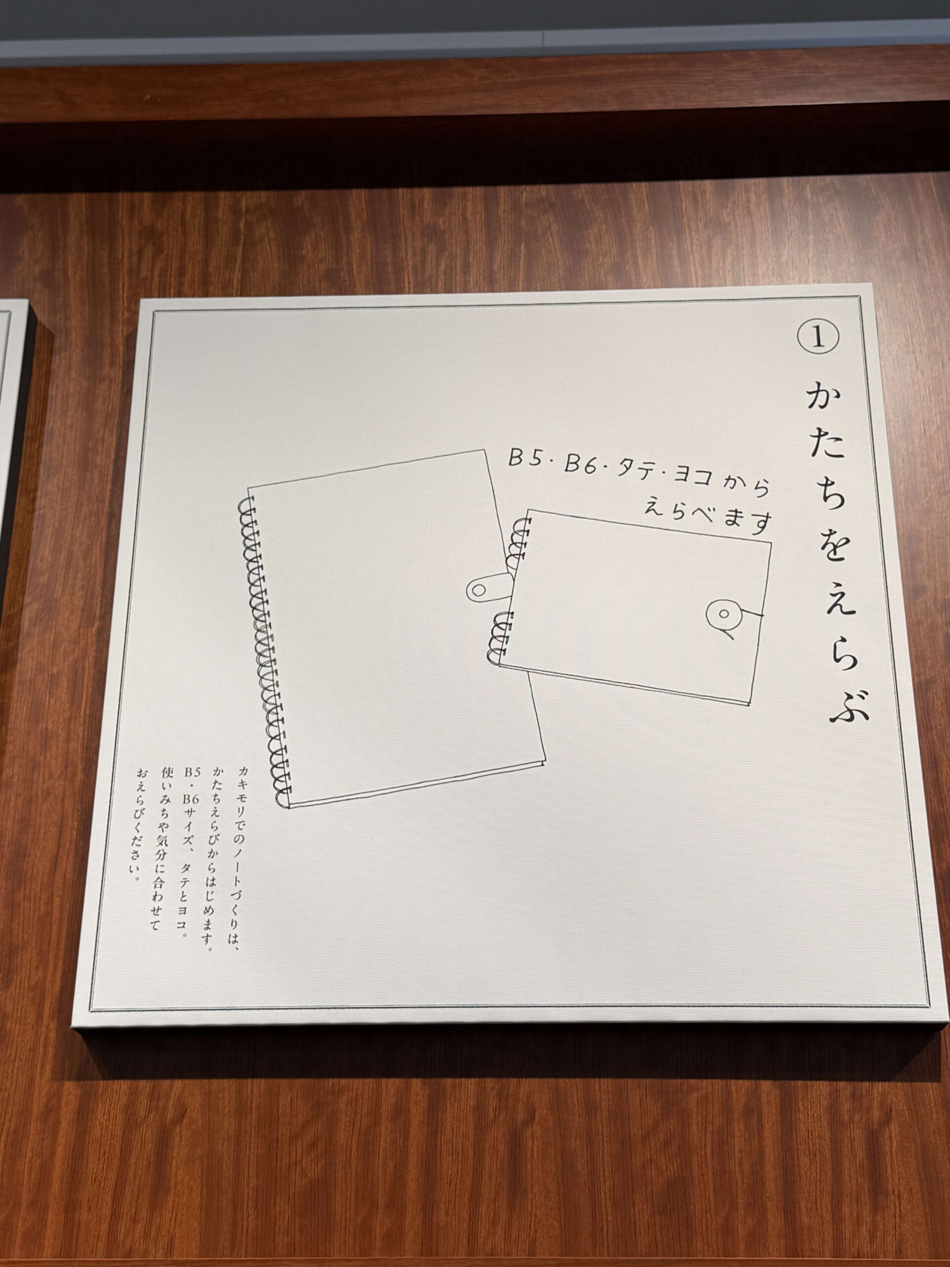 Kakimori custom notebook sign on a wooden wall.