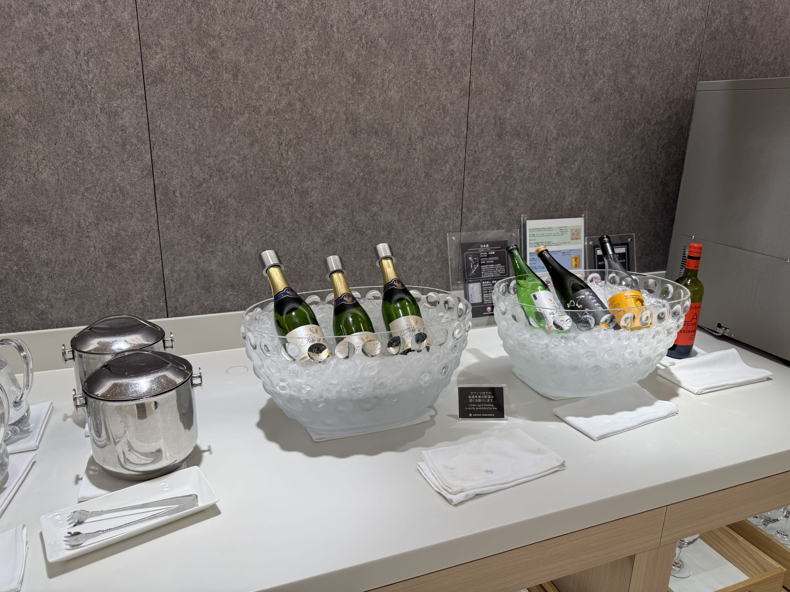 Wine and sake bottles chilled in ice bowls.