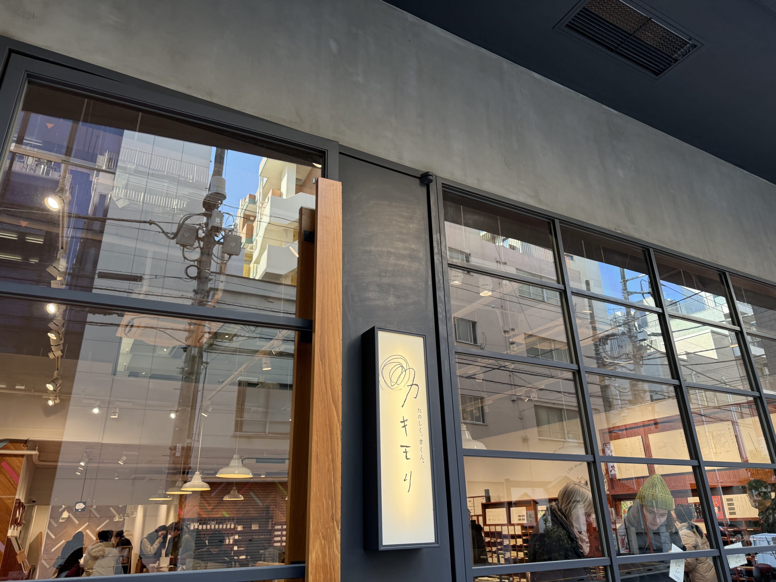 Kakimori exterior. Glass windows reflect the city.