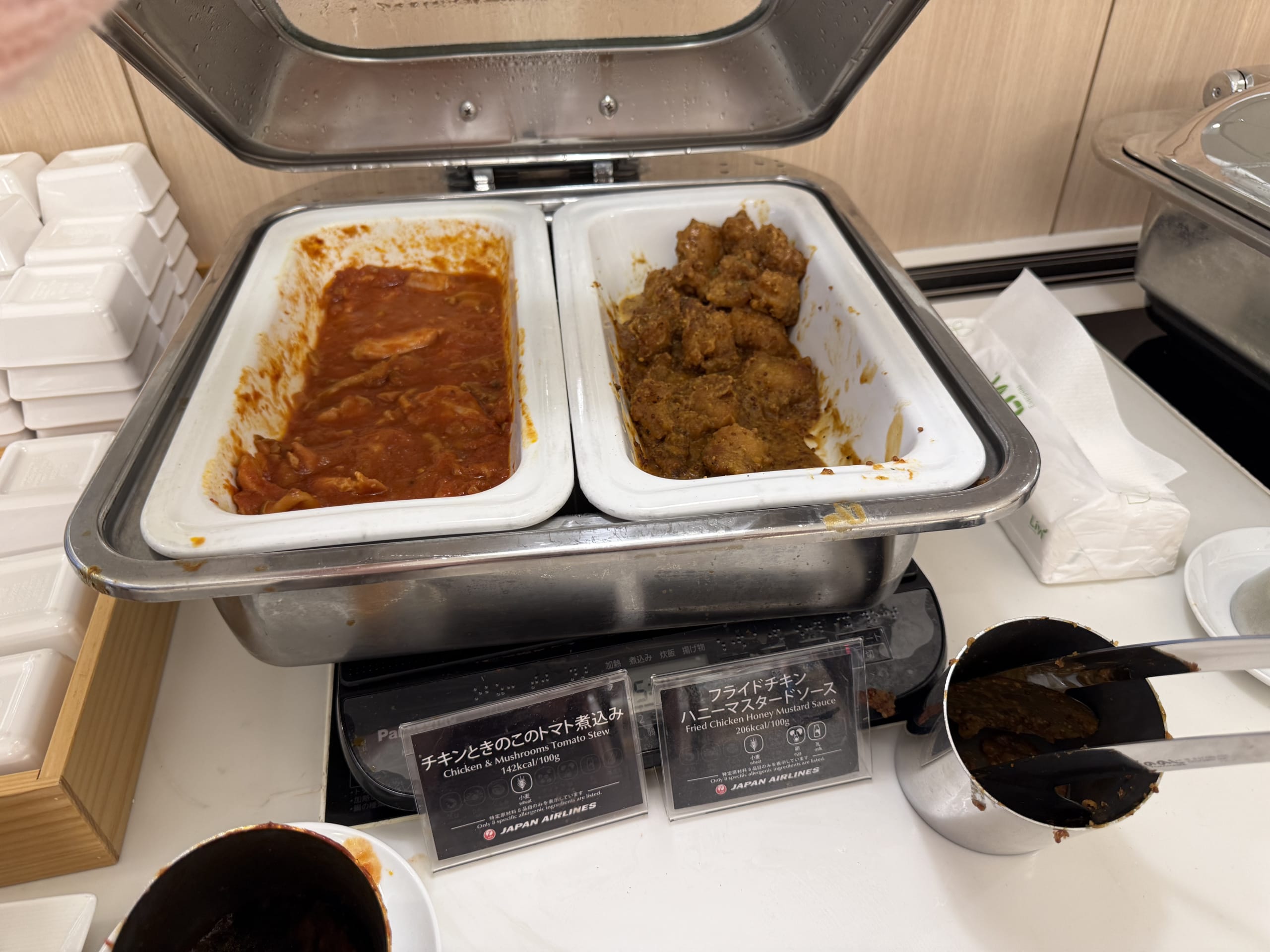 Two chicken dishes at an airport lounge buffet.