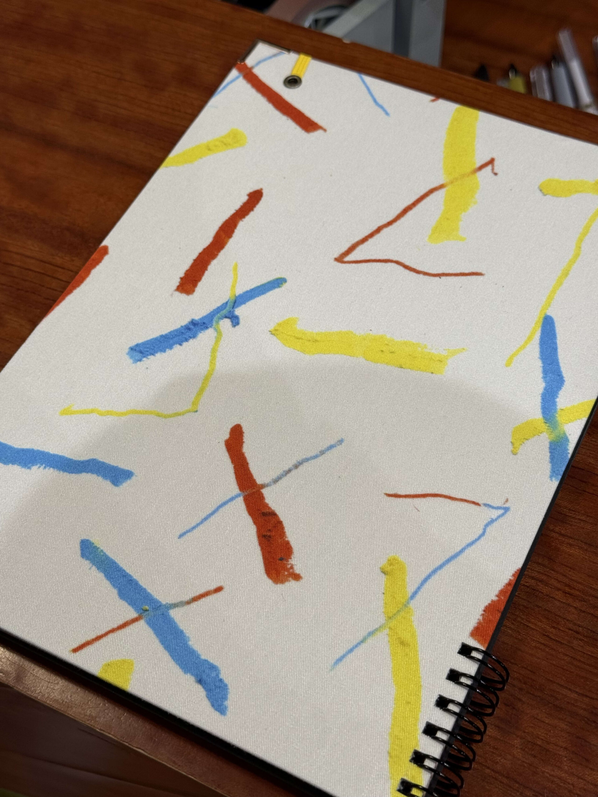 Spiral notebook with colorful patterns on a desk.