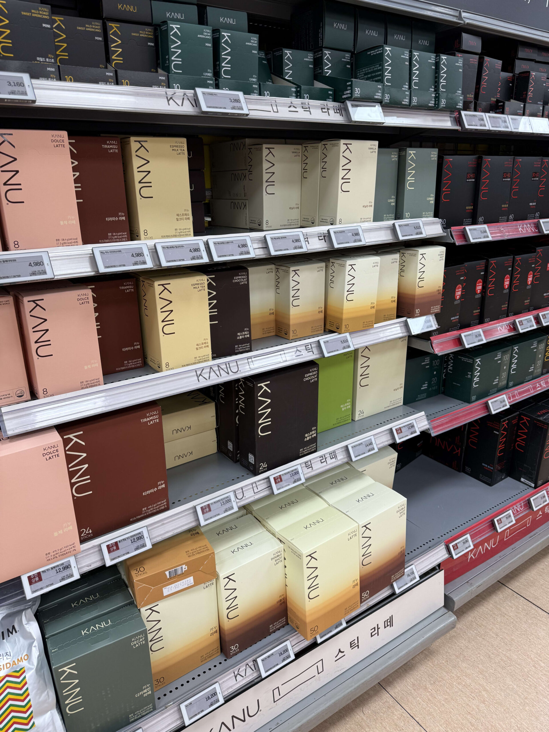 KANU stick coffee boxes displayed on shelves.
