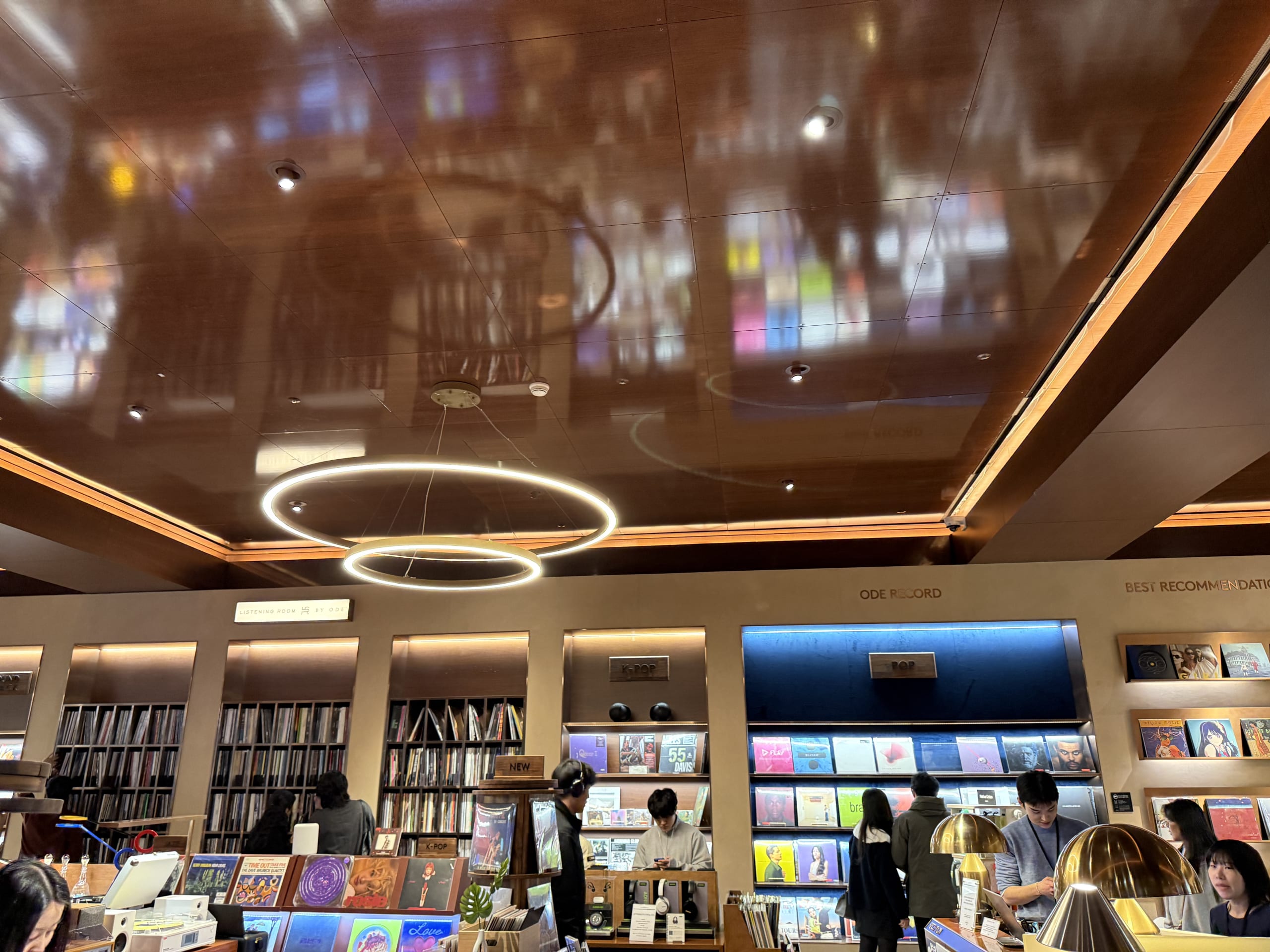 Customers listening to records at a sleek vinyl store.