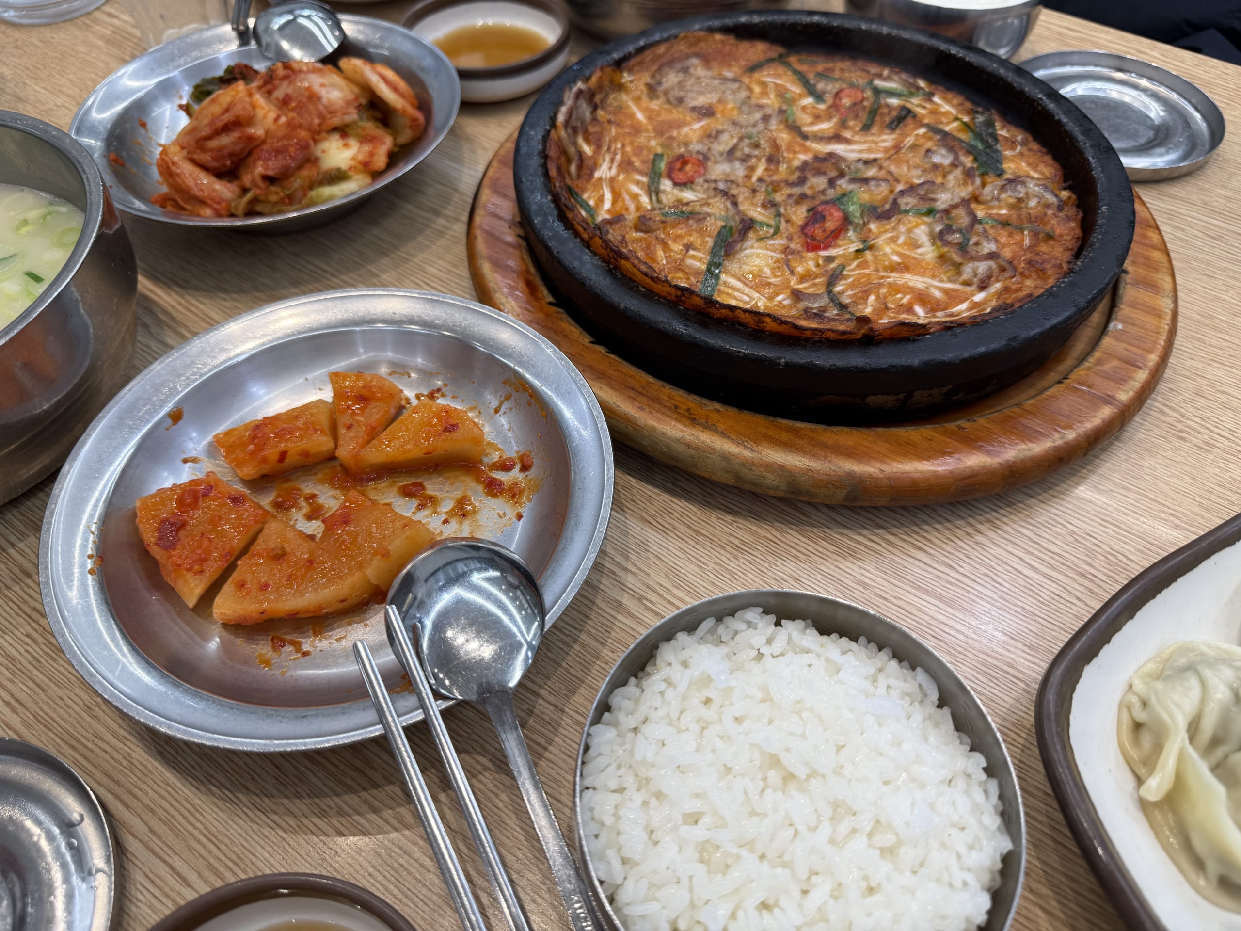 Hot jeon, kimchi, and rice on a table.
