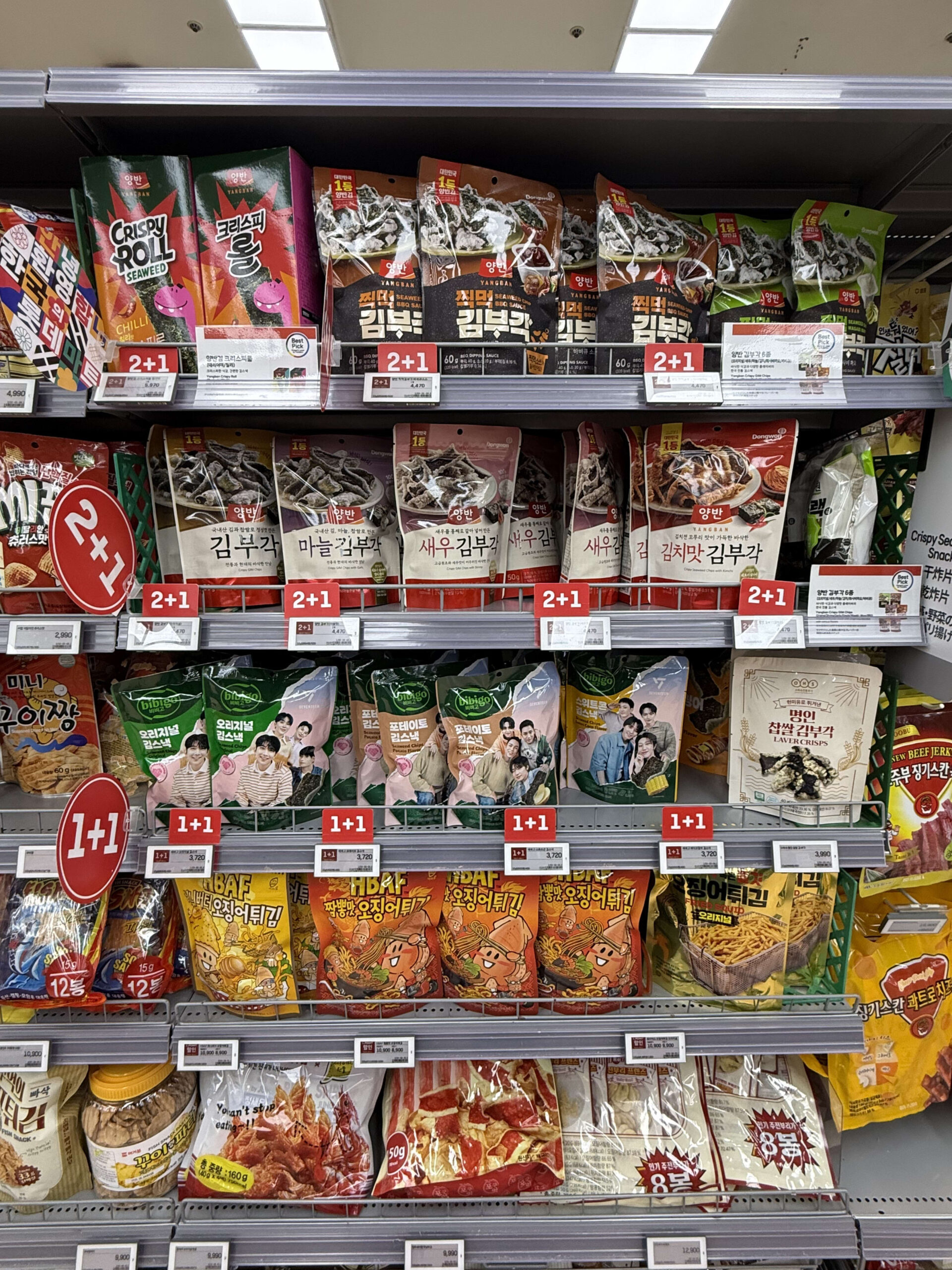 Shelves with Korean snacks and red promo signs.