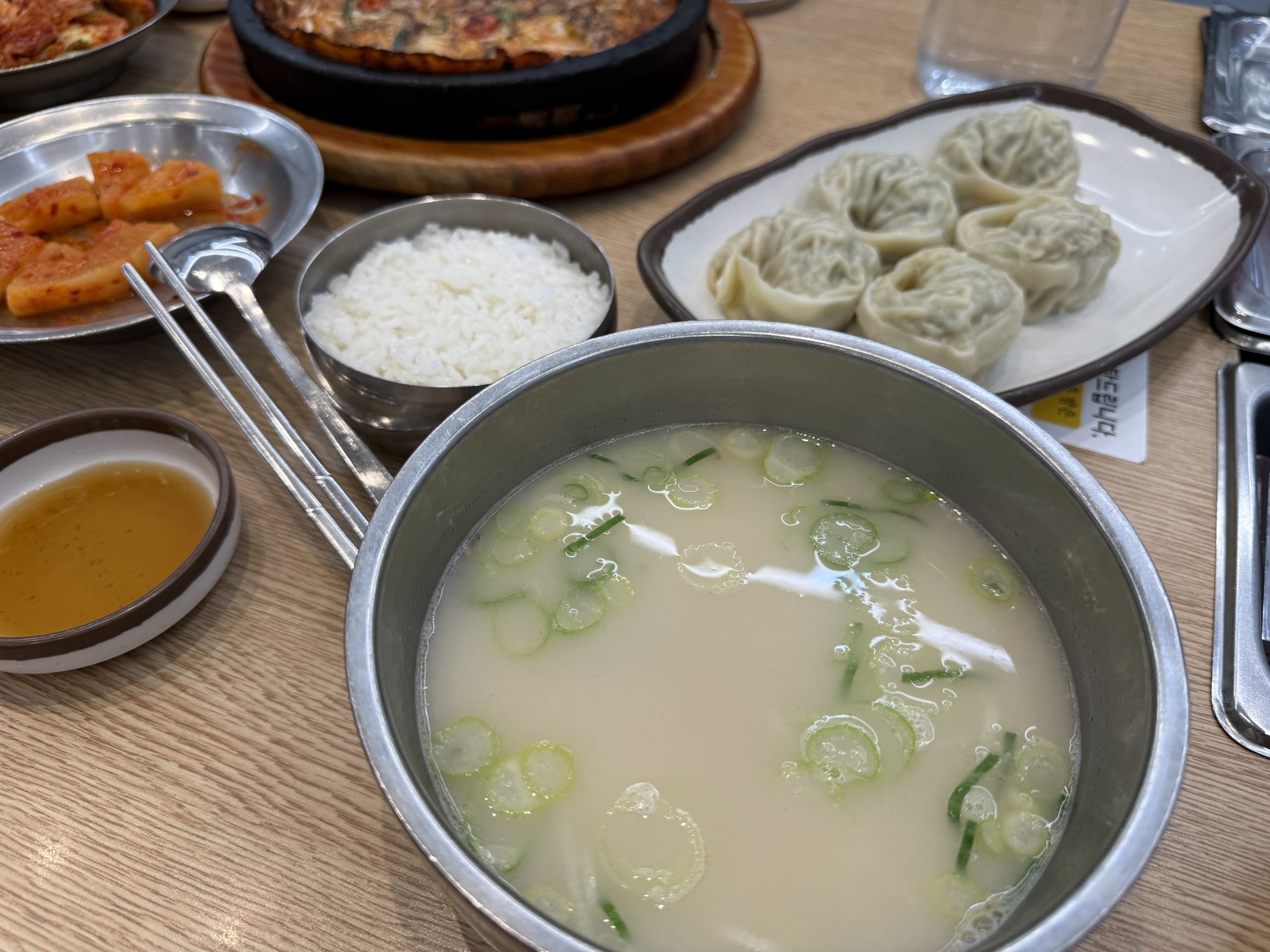 Seolleongtang, rice, kimchi, and mandu on a table