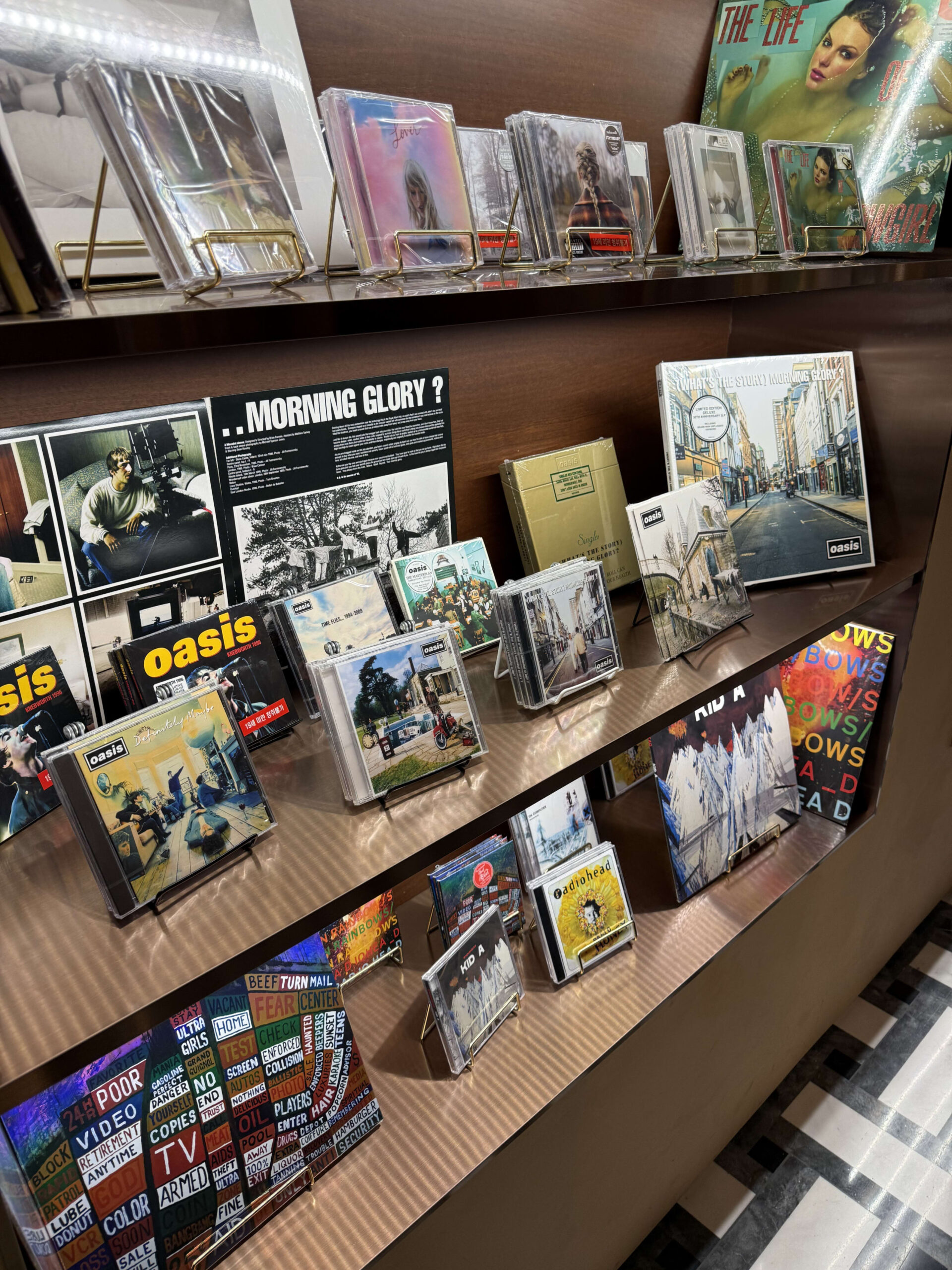 Oasis and Radiohead records on a wooden shelf.