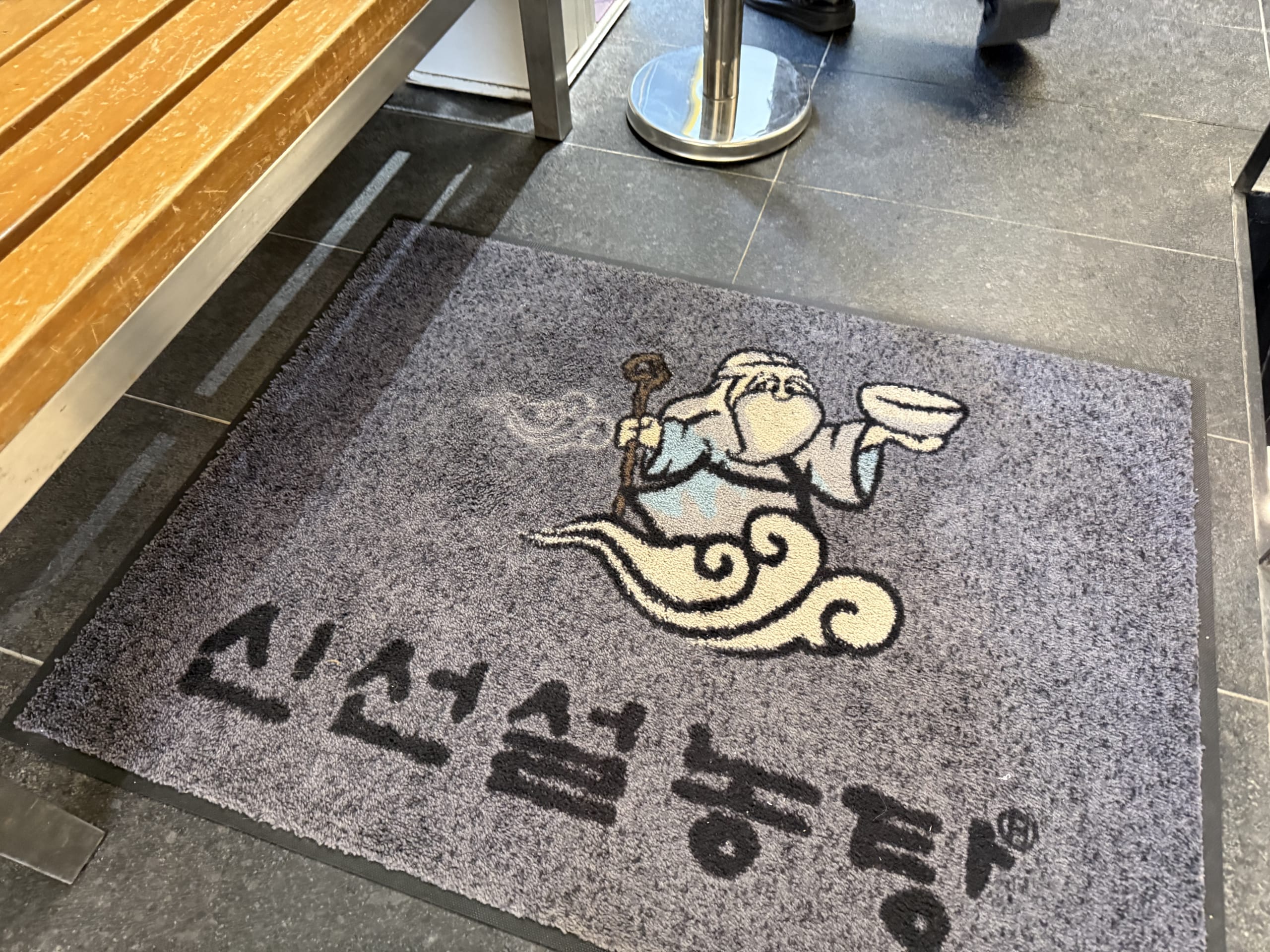 Entrance mat of Sinseon Seolleongtang showing a deity.
