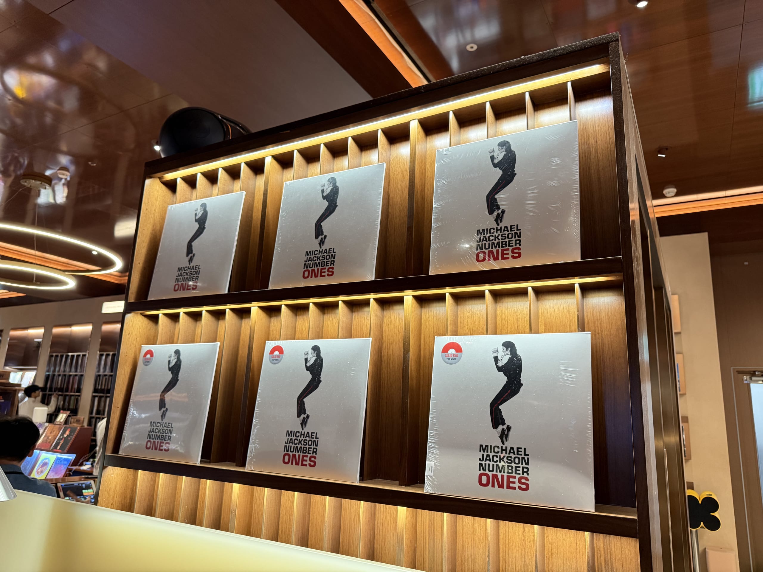 Michael Jackson records on a lit wooden rack.