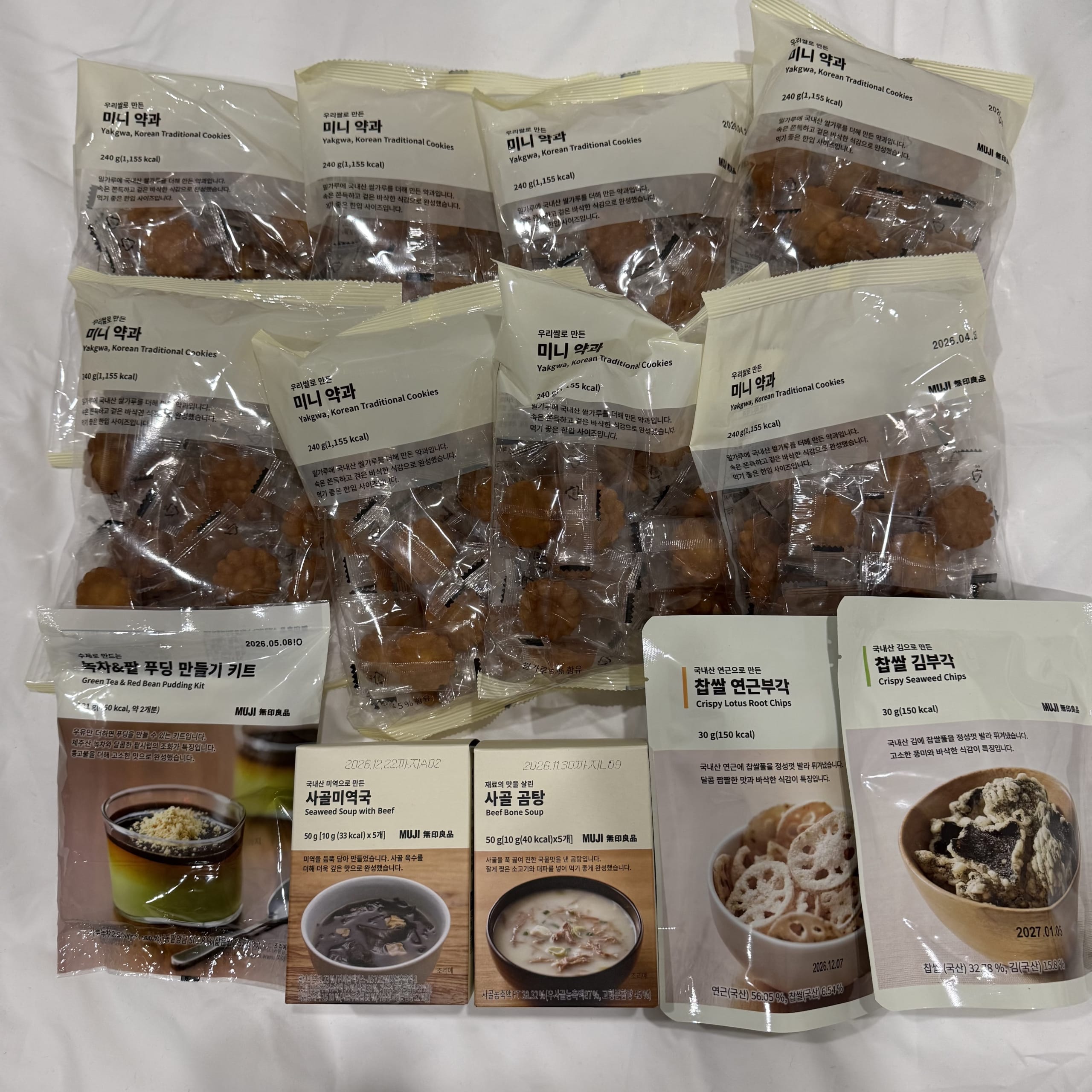 MUJI Korea limited items like mini yakgwa and soup on a bed.