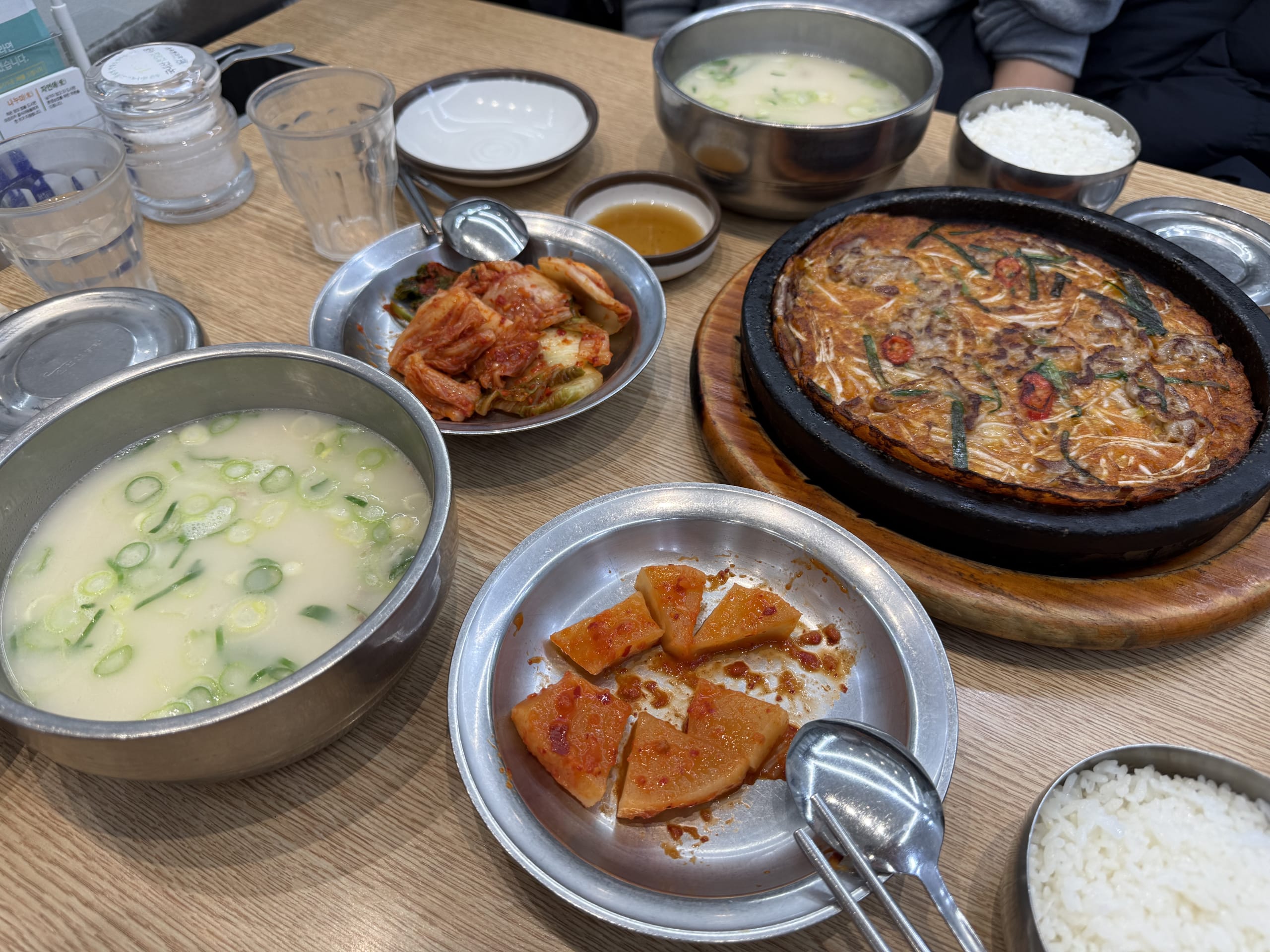 Korean dishes like milky soup, pancake, and kimchi.