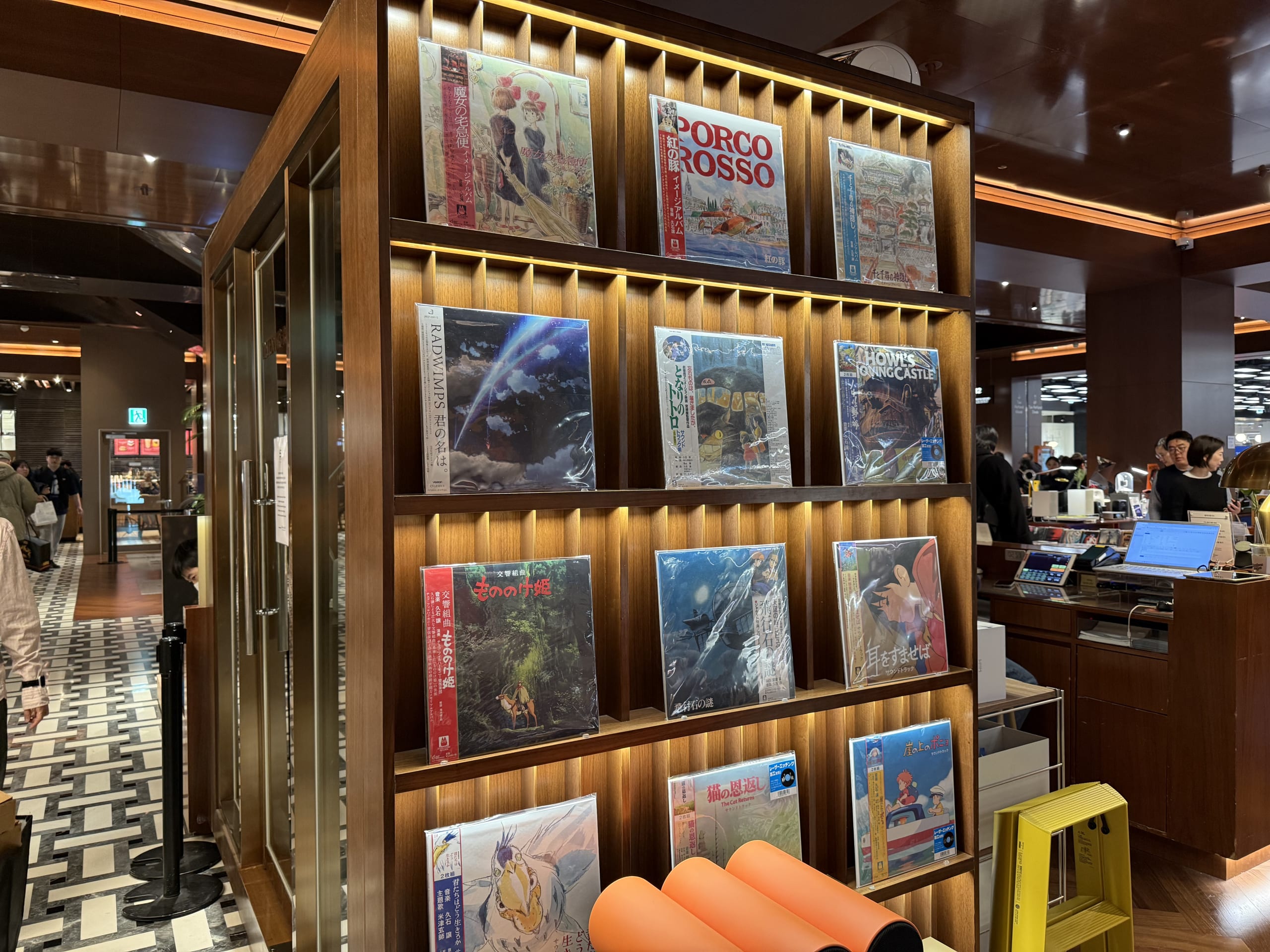 Japanese records on a lit wooden shelf.