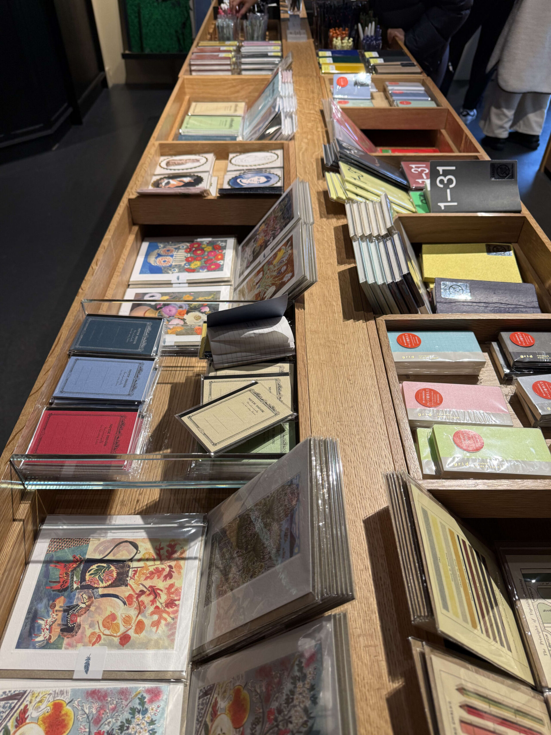 Various stylish stationery displayed on wooden tables.