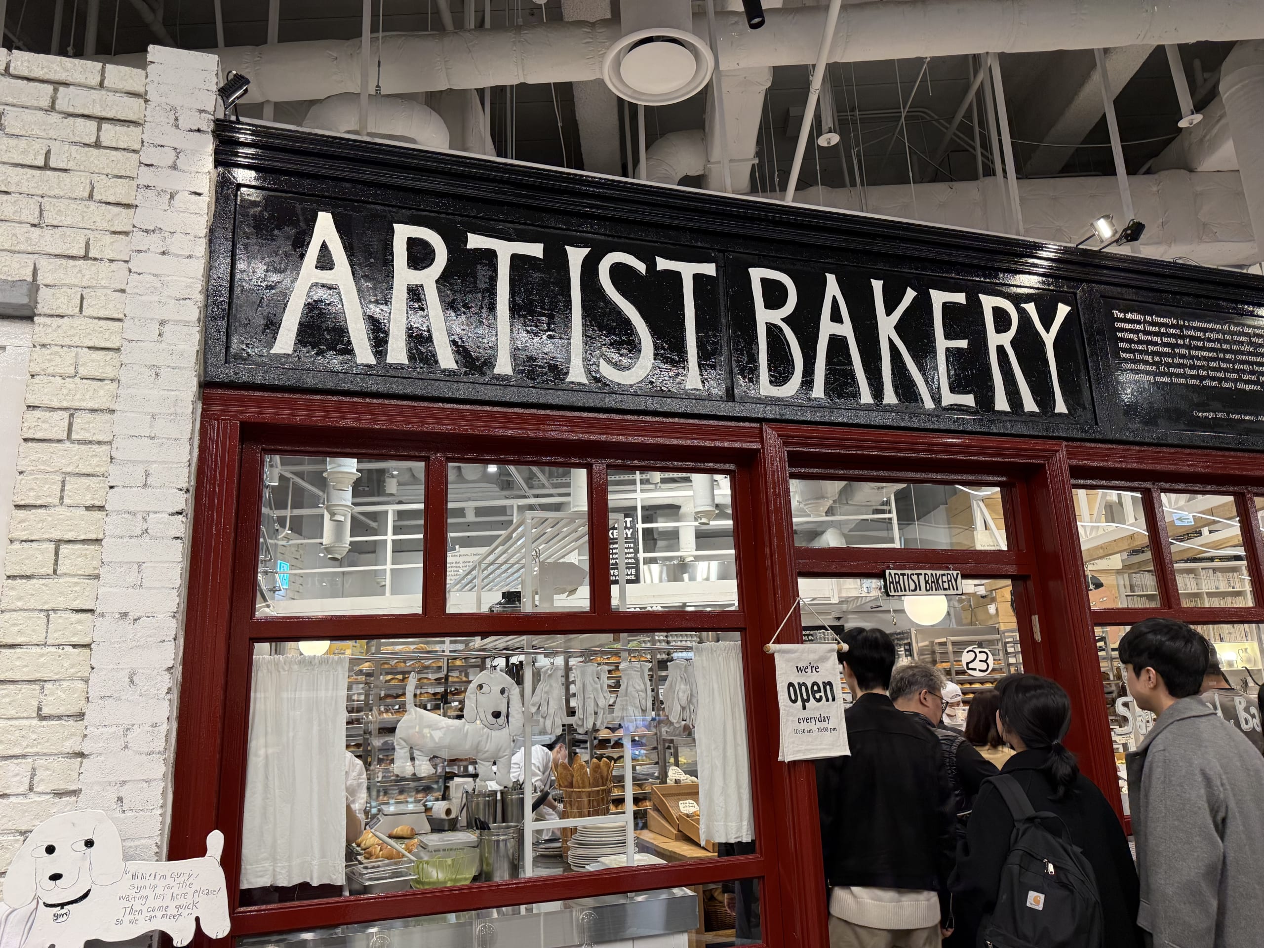 The white brick facade and humorous illustrations of ARTIST BAKERY