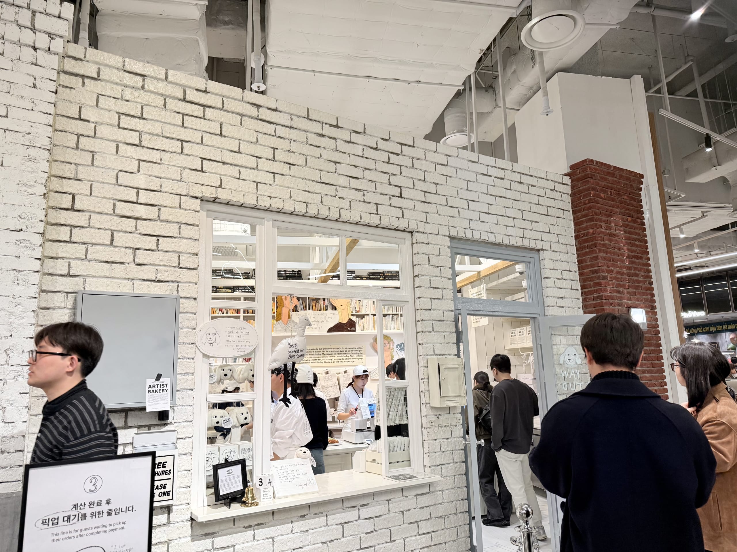 ヒュンダイソウルにある白レンガのパン屋「アーティストベーカリー」と待機する客。