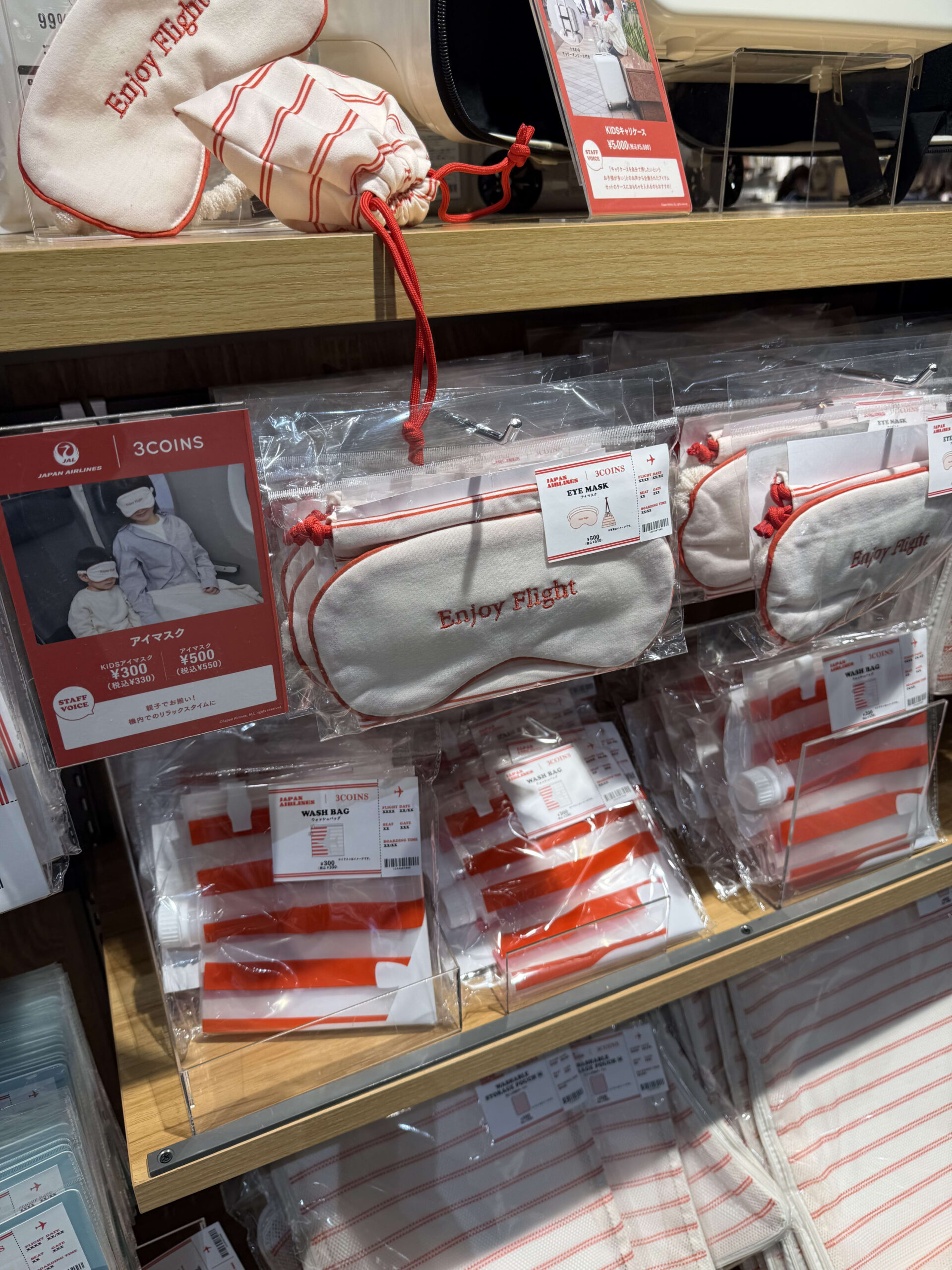 3COINSの棚に並ぶJALコラボのアイマスク等の旅行用品。