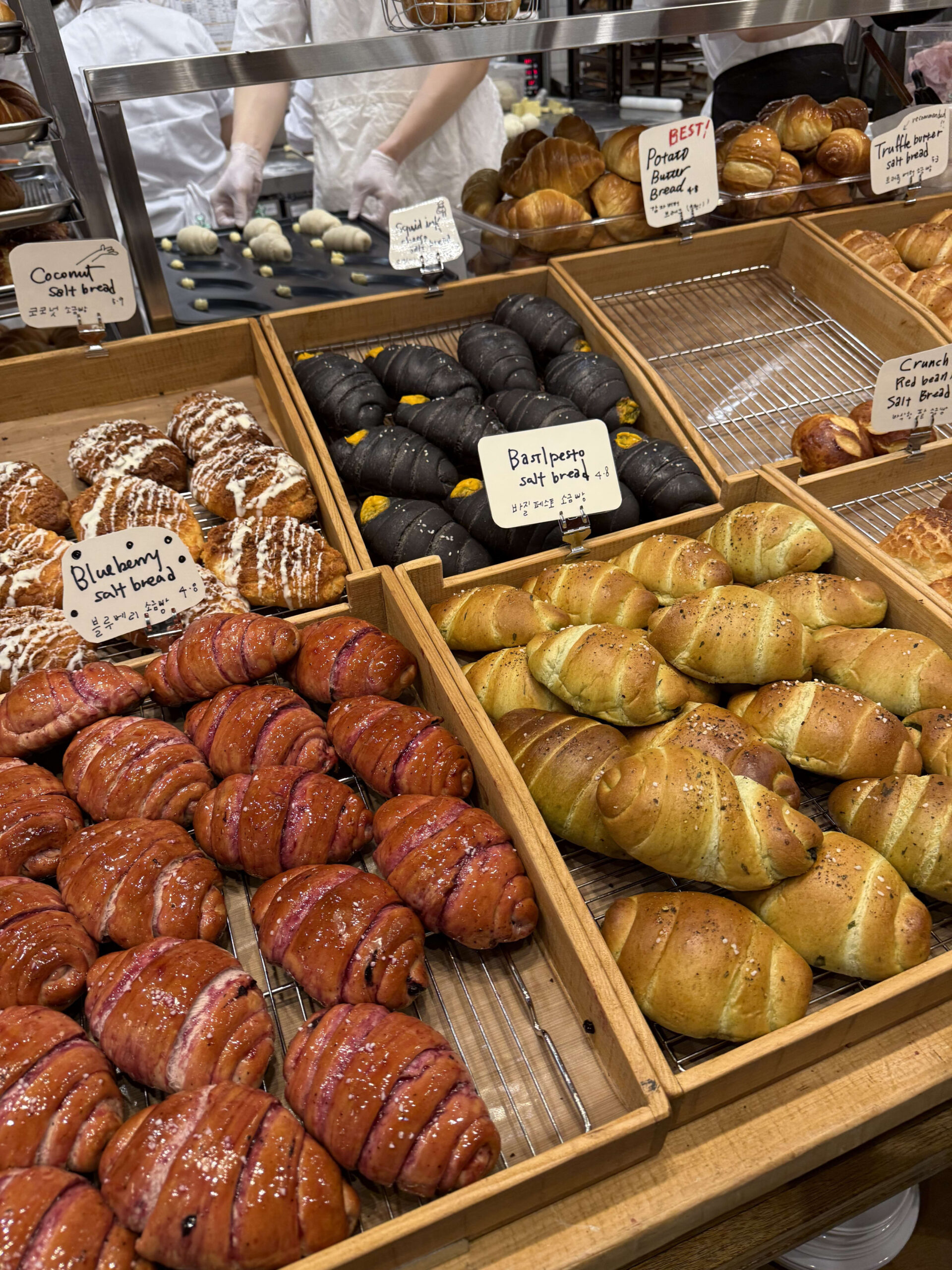 Colorful salt breads on wooden trays in a bakery.