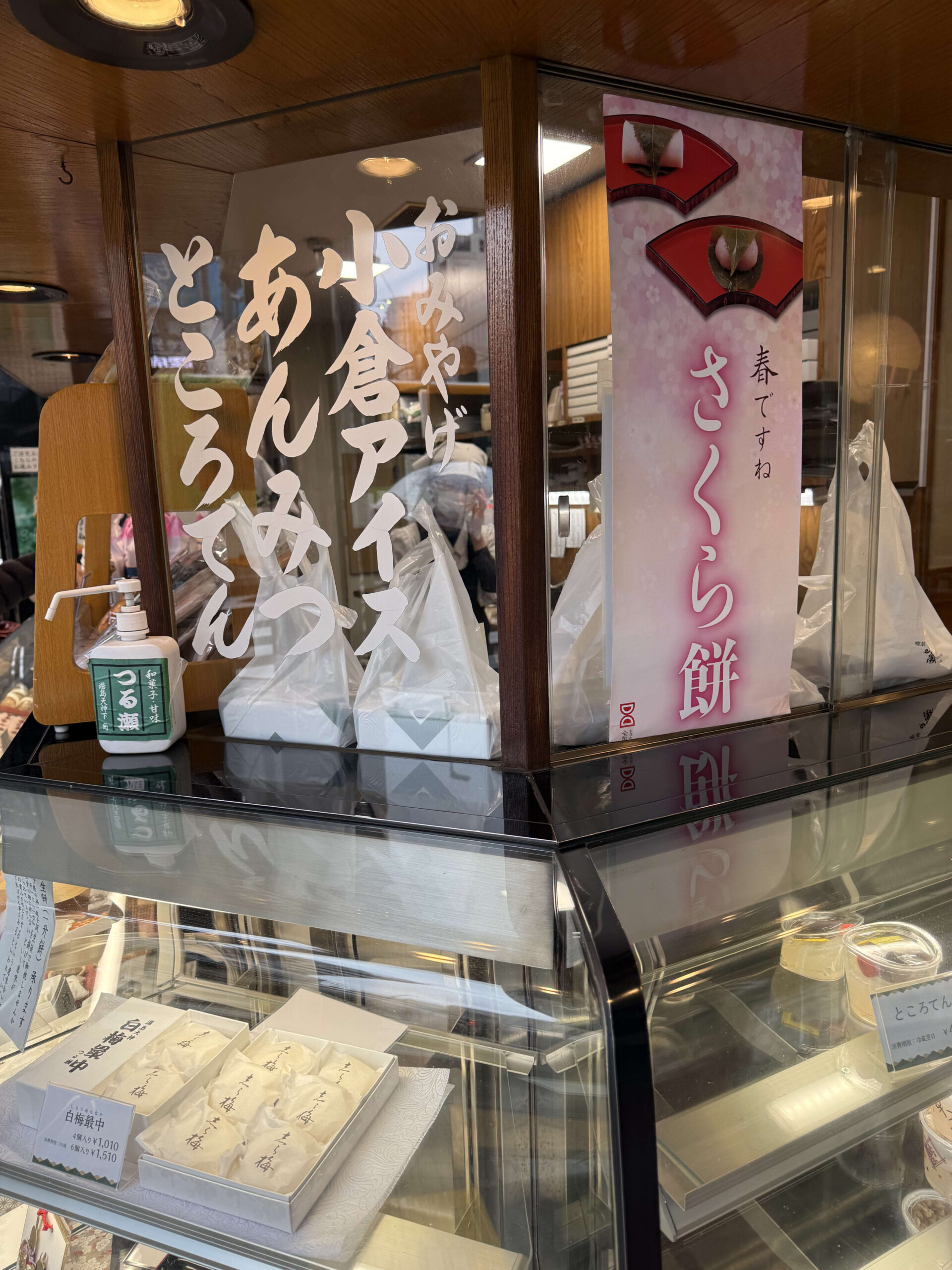 和菓子店つる瀬の店頭。ガラスの筆文字と桜餅のポスター。