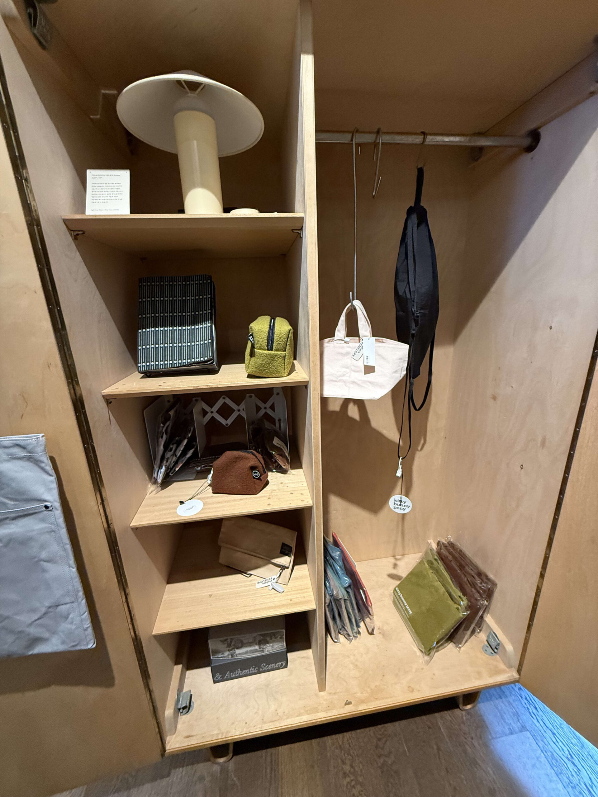 Bags and pouches in a wooden wardrobe display.