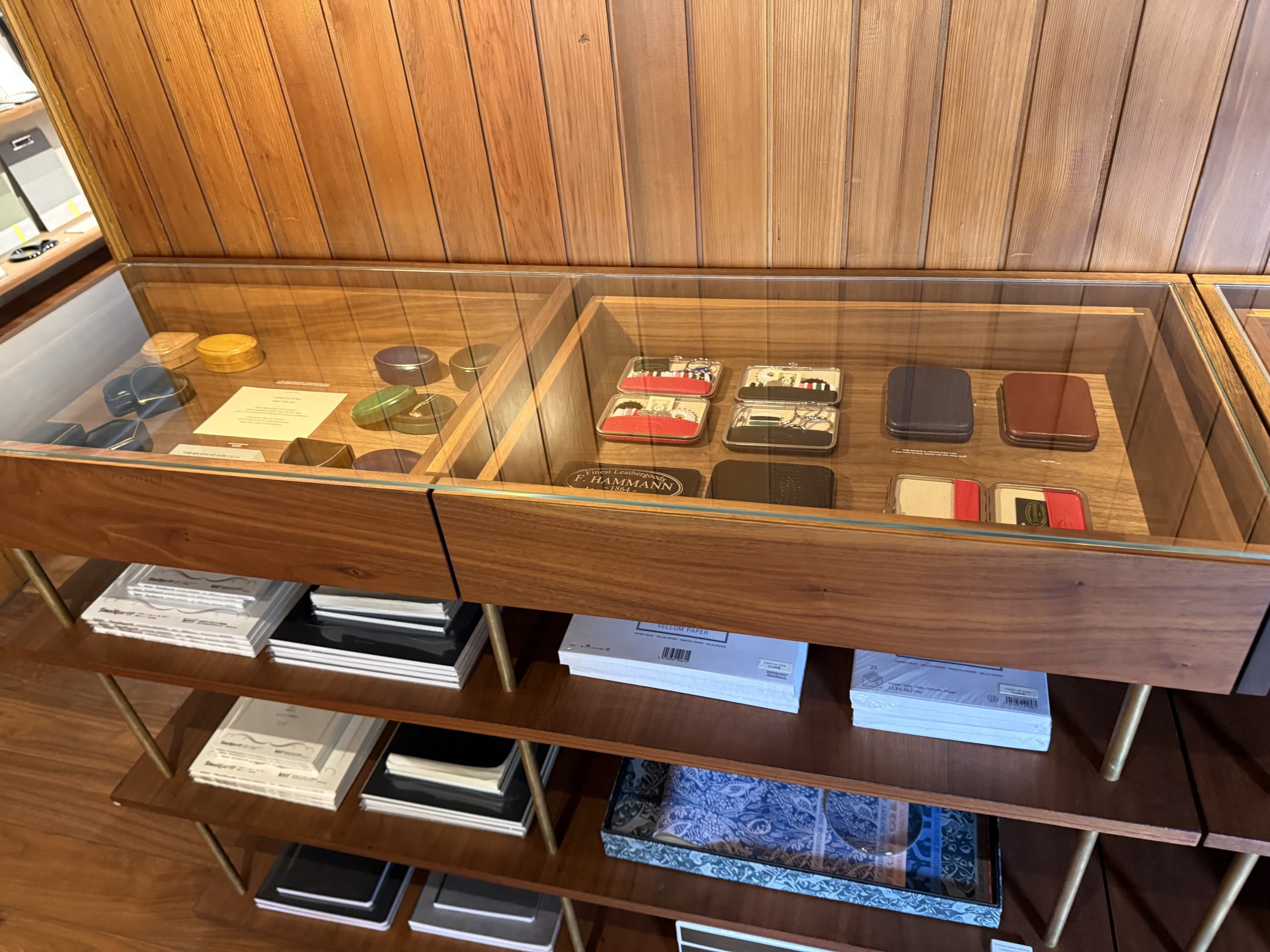 Leather stationery and notebooks in a glass case.