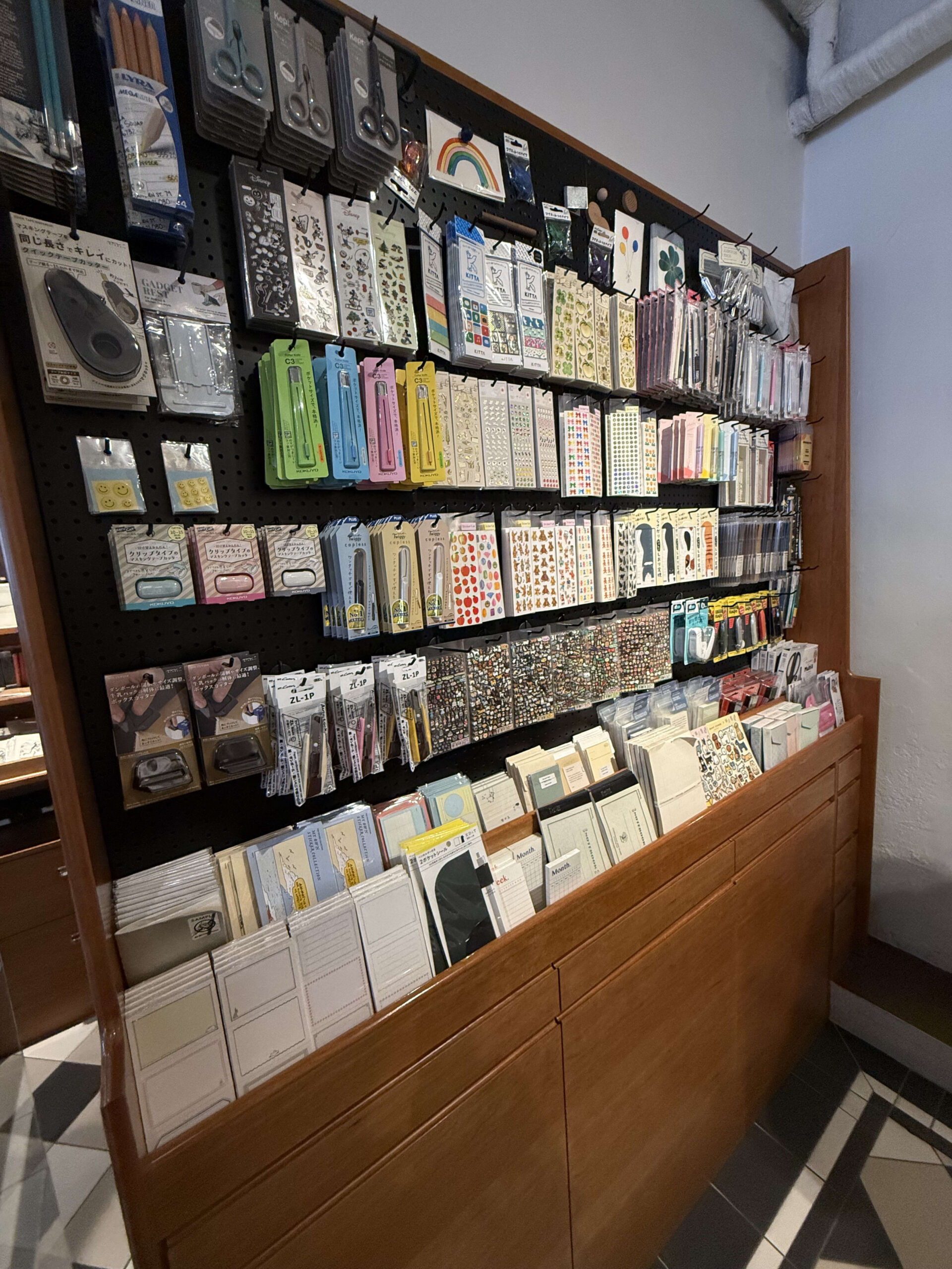 Various stationery on a pegboard and wooden shelves.