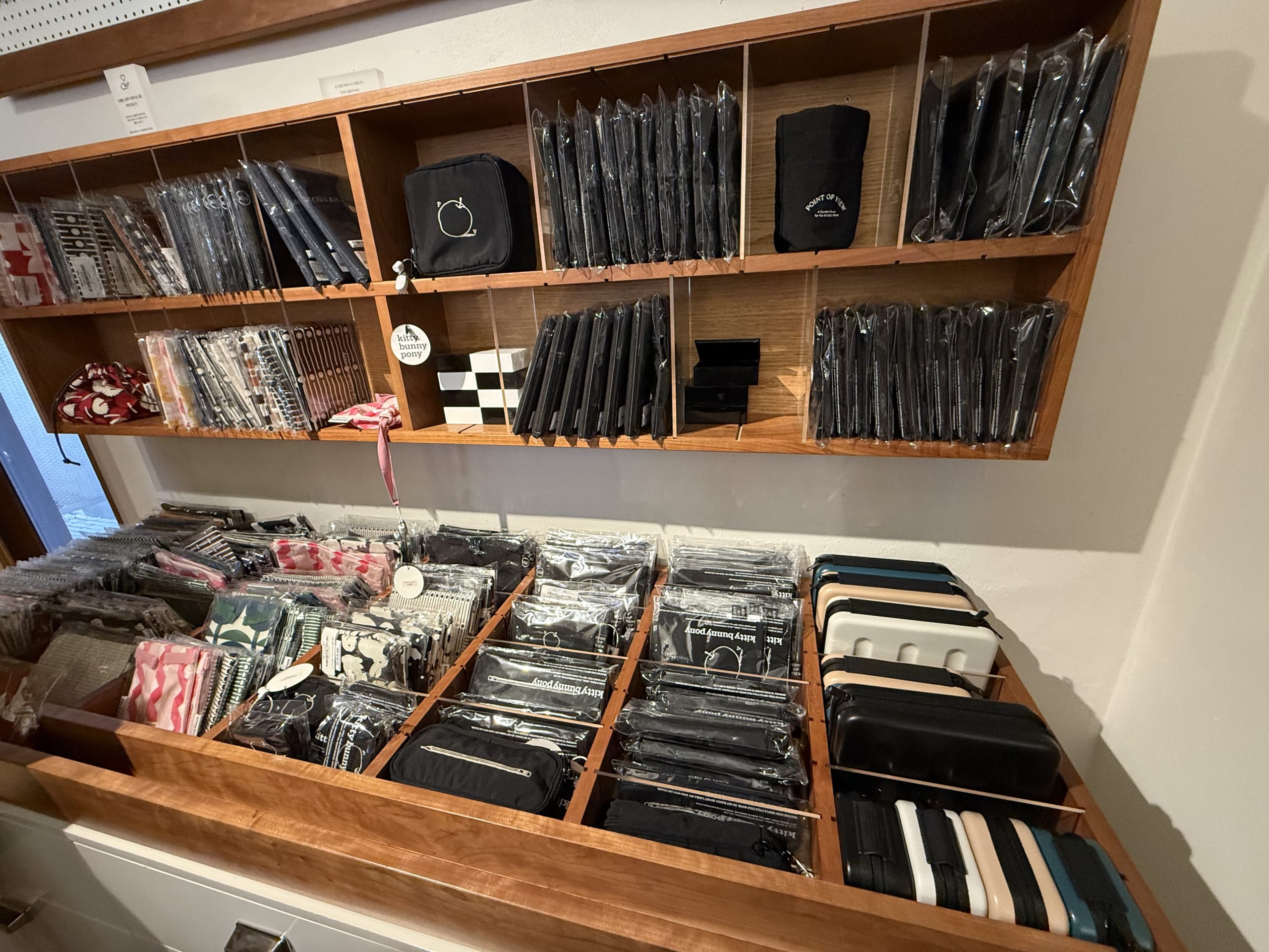 Pouches and cases on wooden shelves.