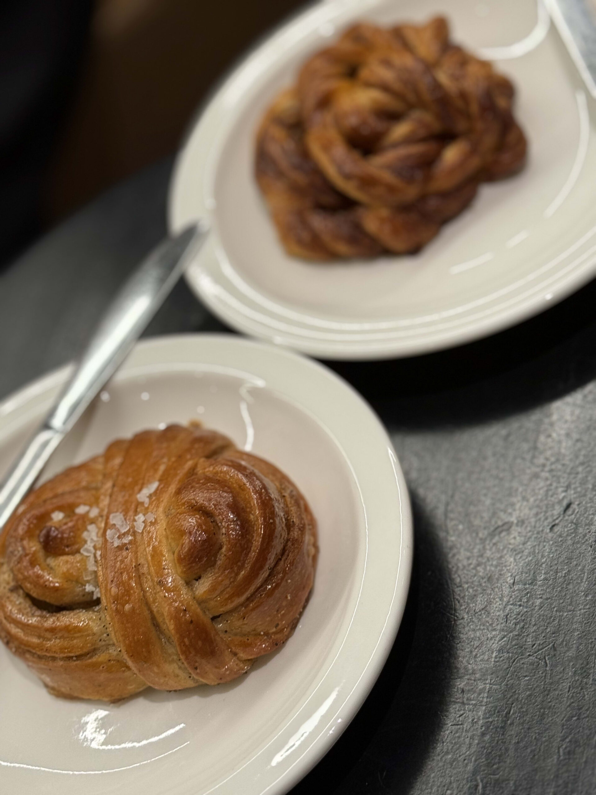 Glossy braided pastries on a white plate.