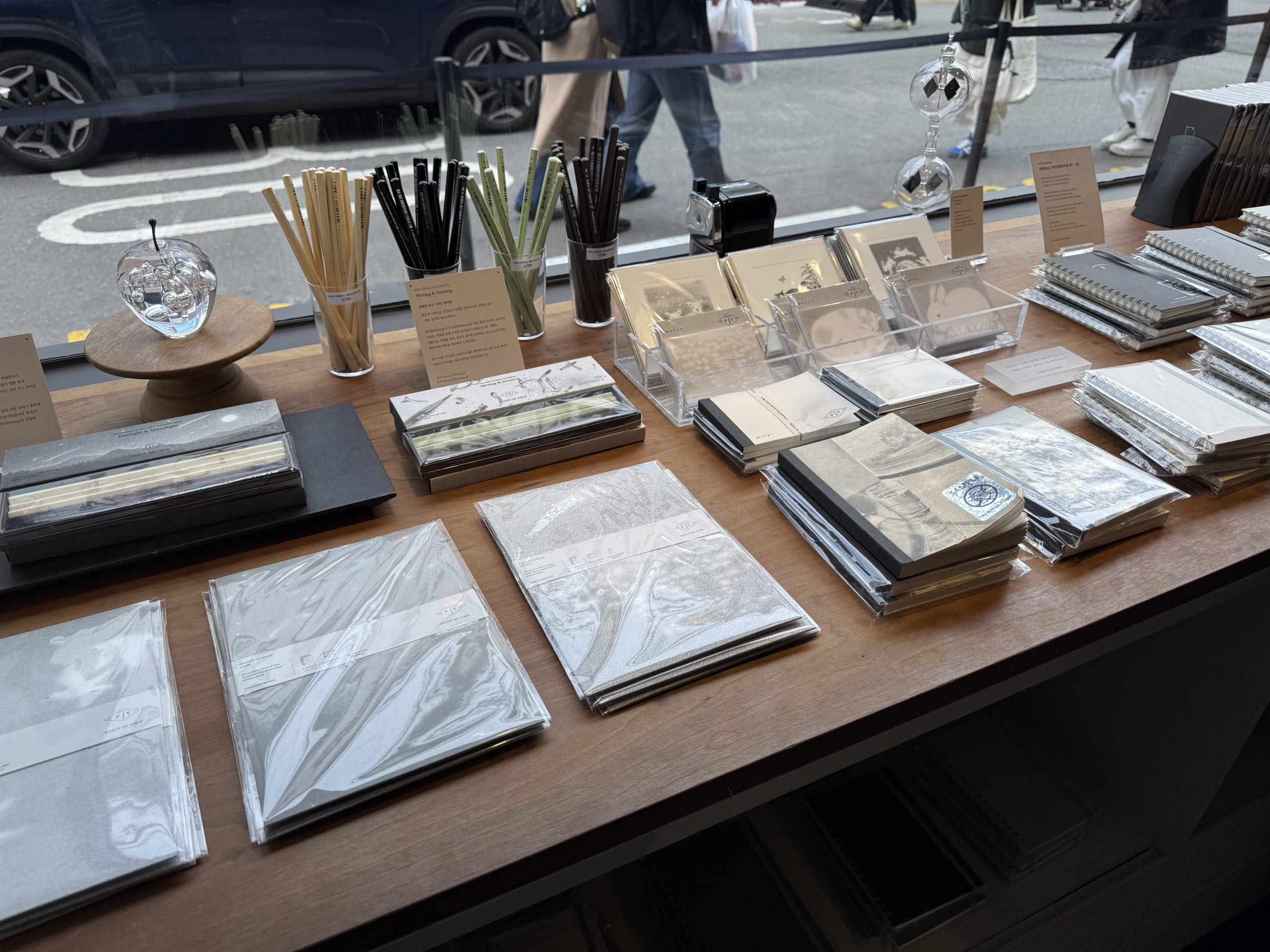 Notebooks, pencils, and other stationery displayed on a table by the window at Point of View in Seoul.