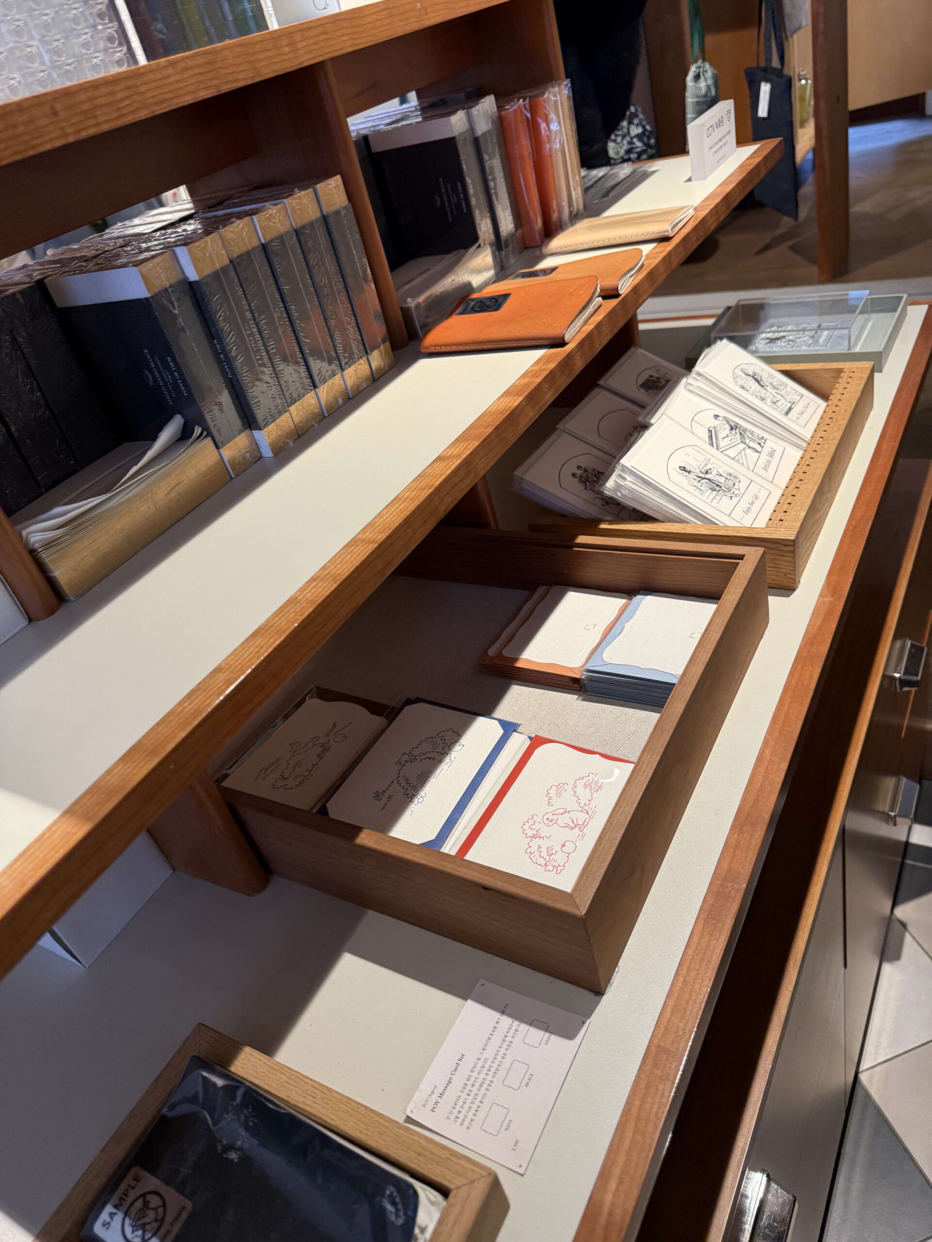 Stationery and cards on wooden shelves.