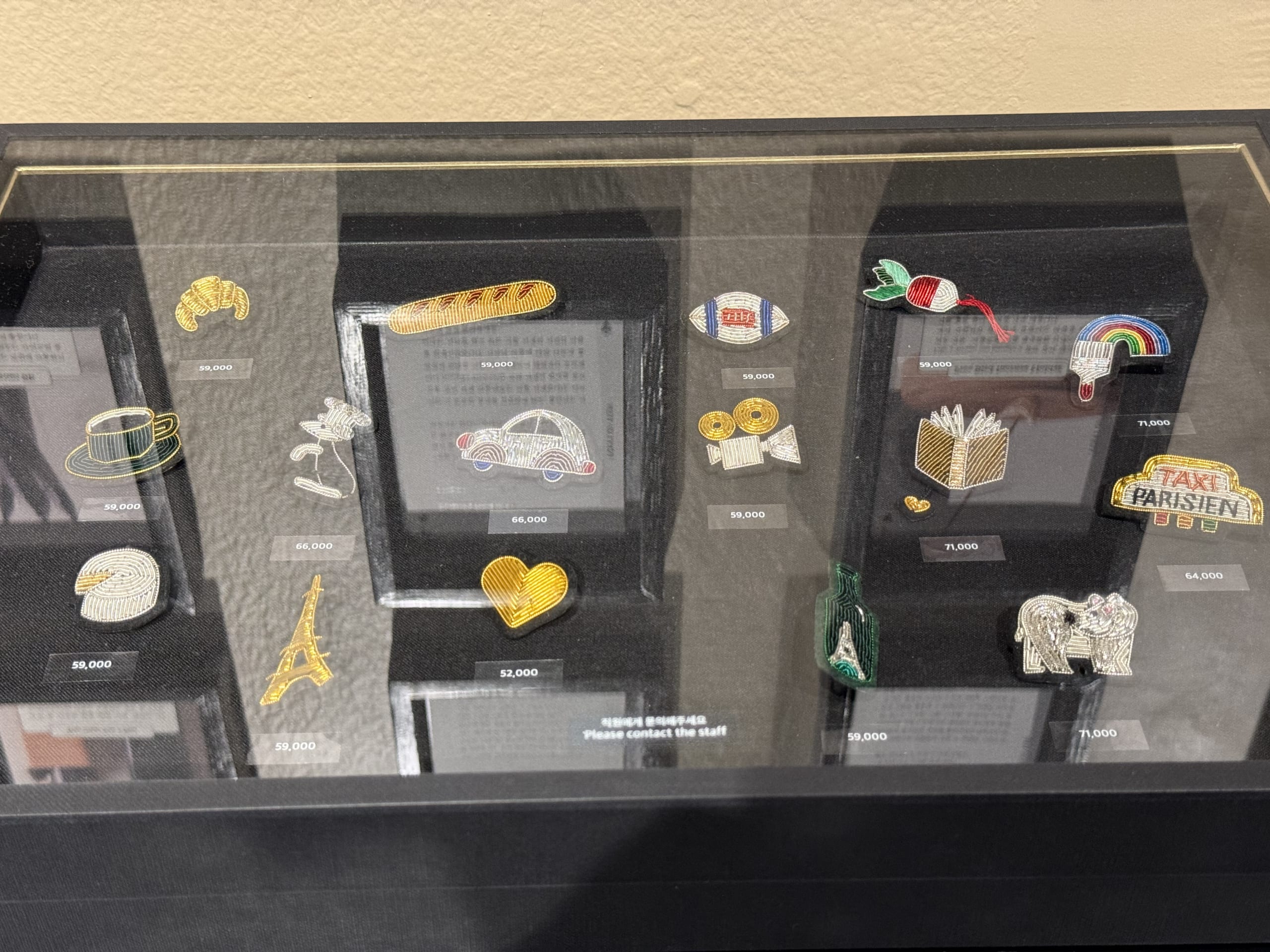 Beaded brooches in a glass display case.
