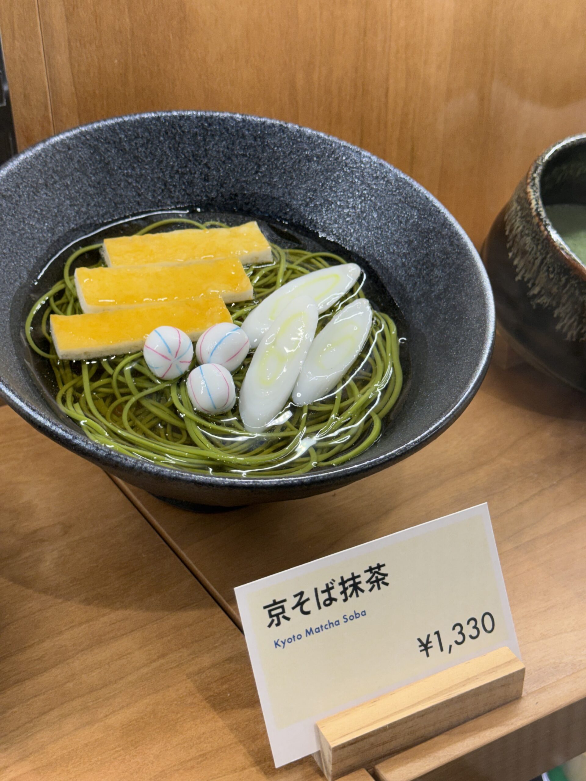 ショーケースに飾られた「京そば抹茶」の食品サンプルと値札。