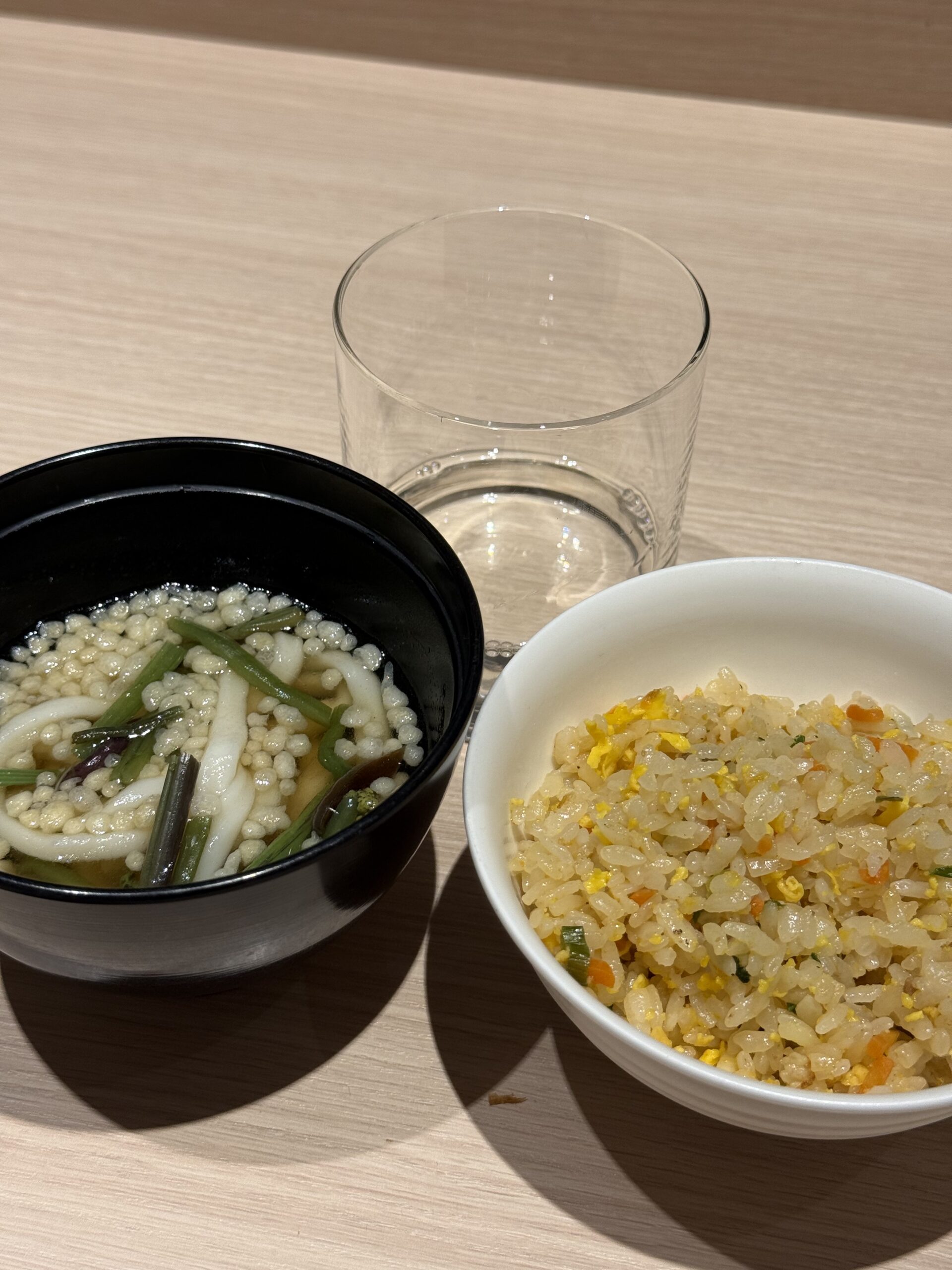 テーブルに置かれた山菜うどんとチャーハン、グラス