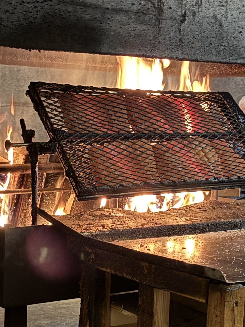 鉄網に挟まれ直火で炙られる肉厚なサーモン
