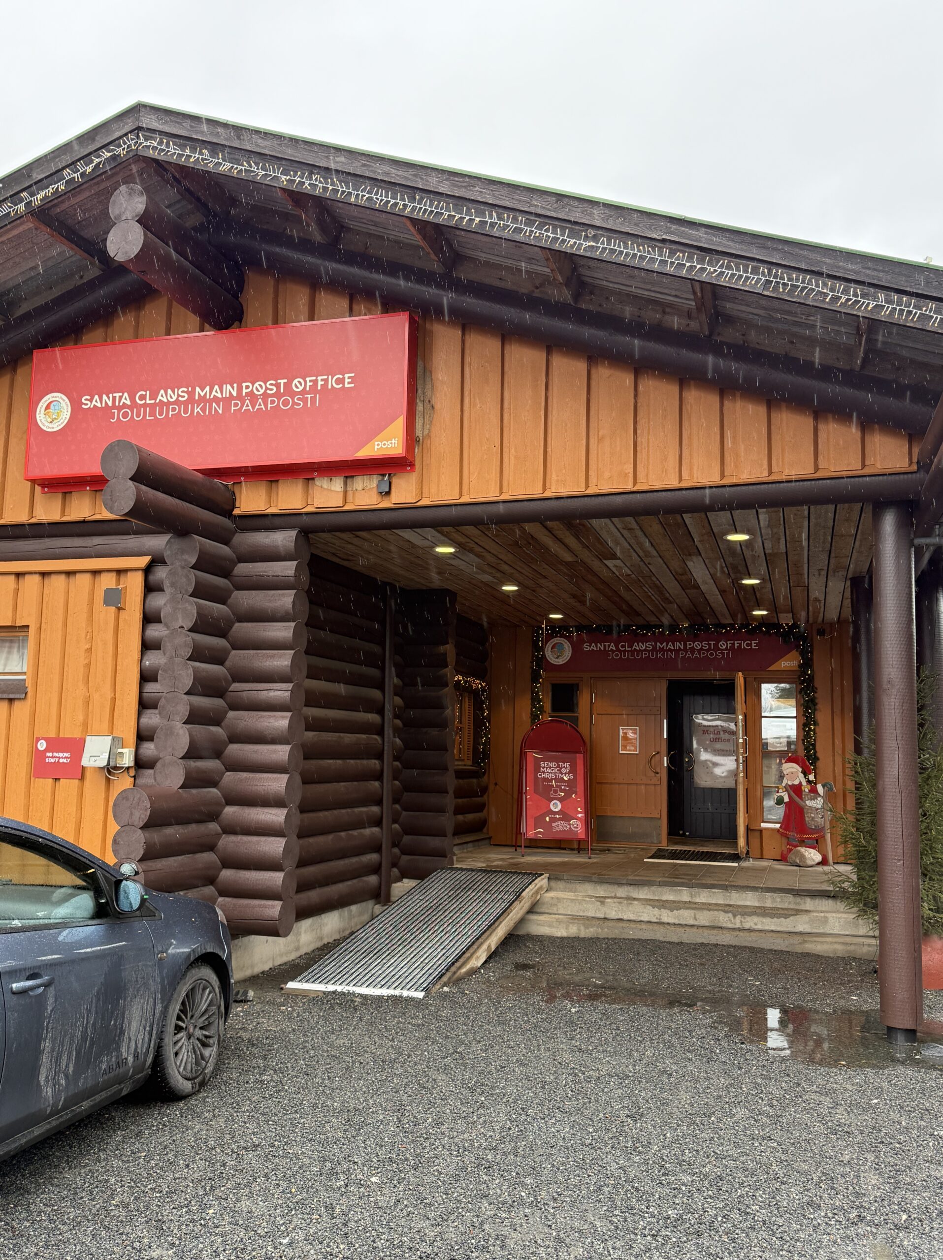 雪降るロヴァニエミのサンタクロース中央郵便局の外観と赤いポスト