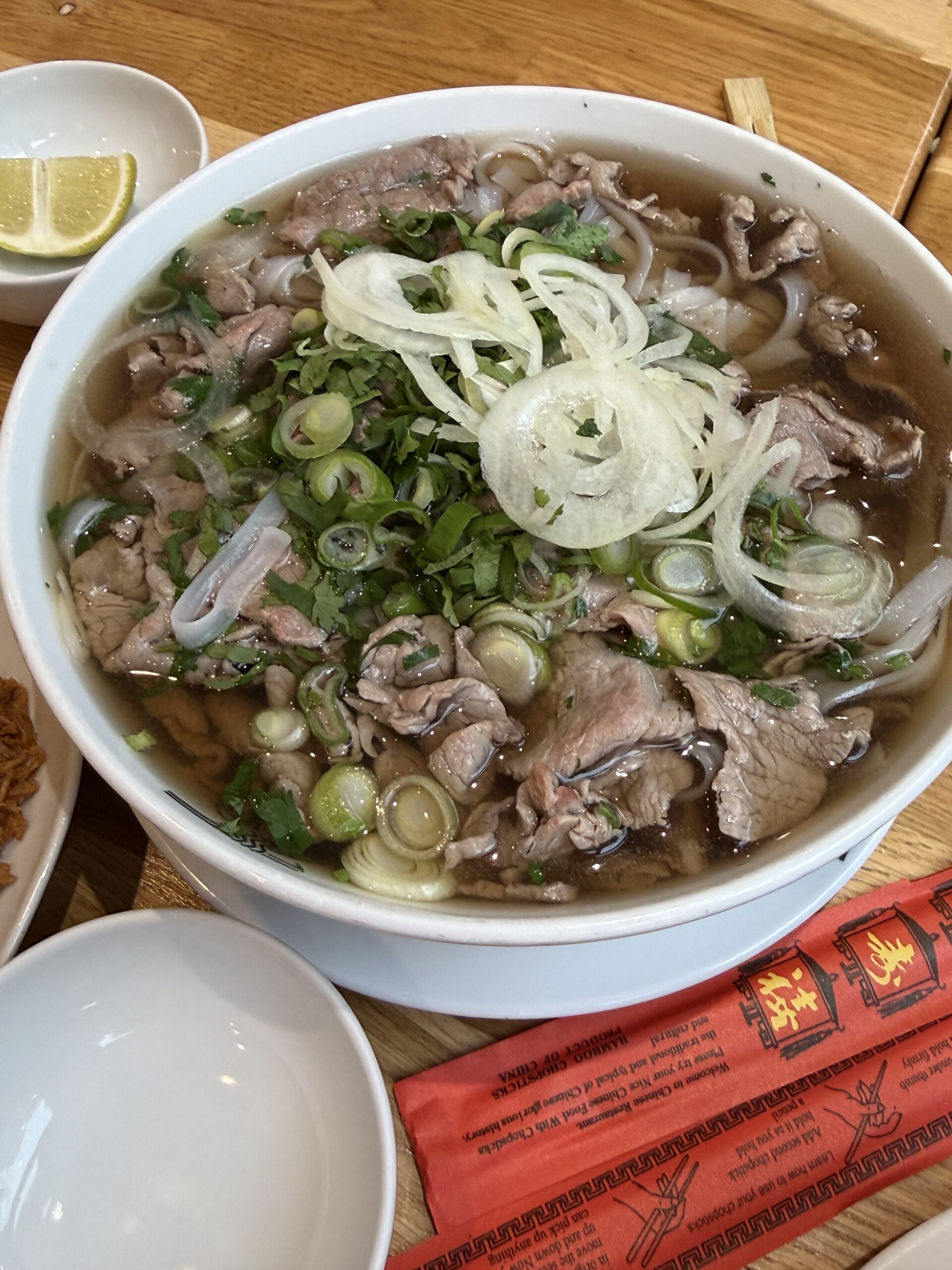 Pho with amber soup generously topped with rare beef