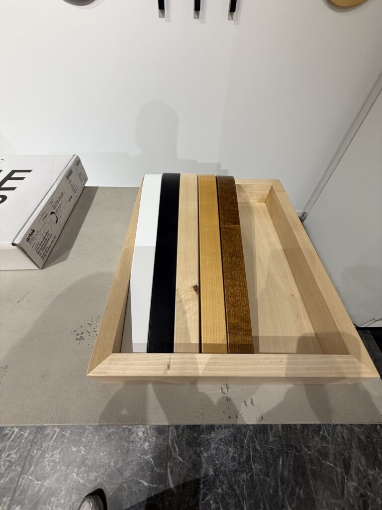 Wooden L-leg samples stacked above flatpack boxes