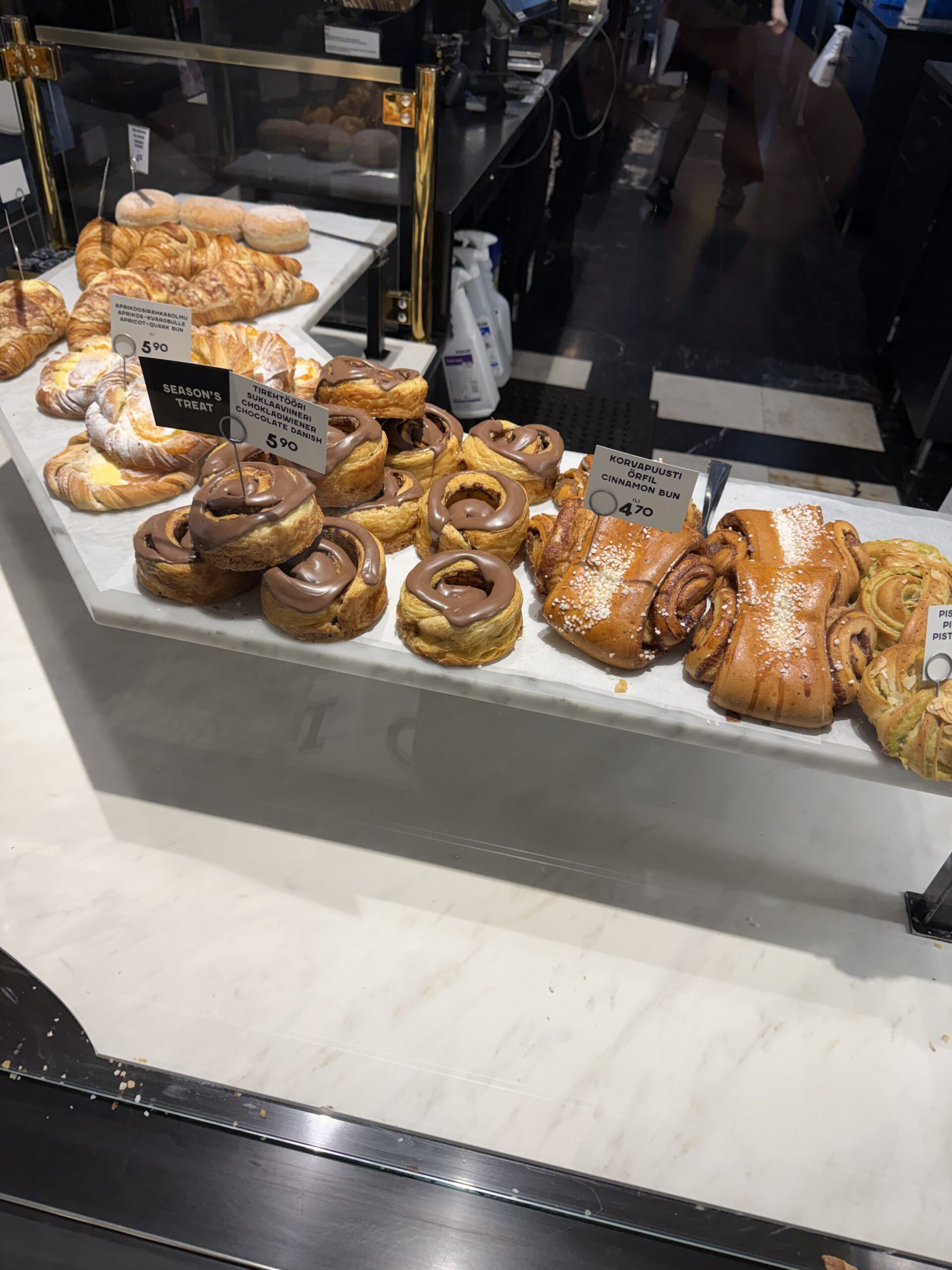 Fazer Cafeのショーケースに並ぶシナモンバンやチョコレートデニッシュなどのペストリー。